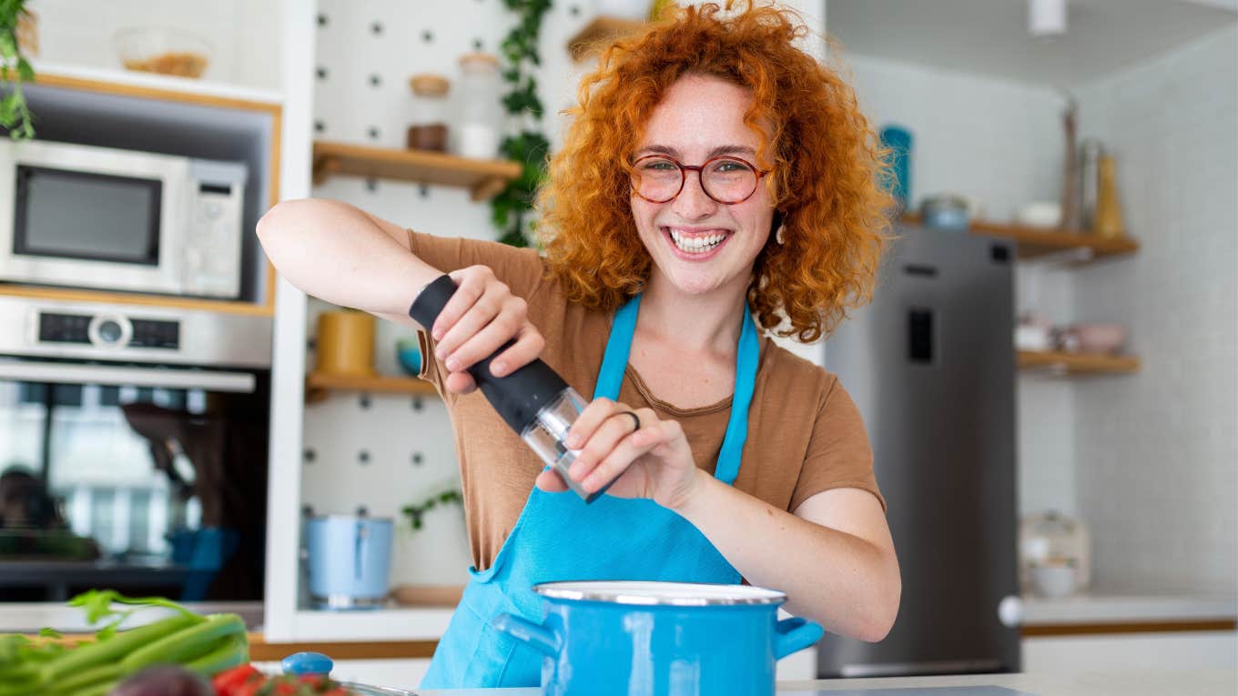 Woman smiling while cooking vegan Thanksgiving meal