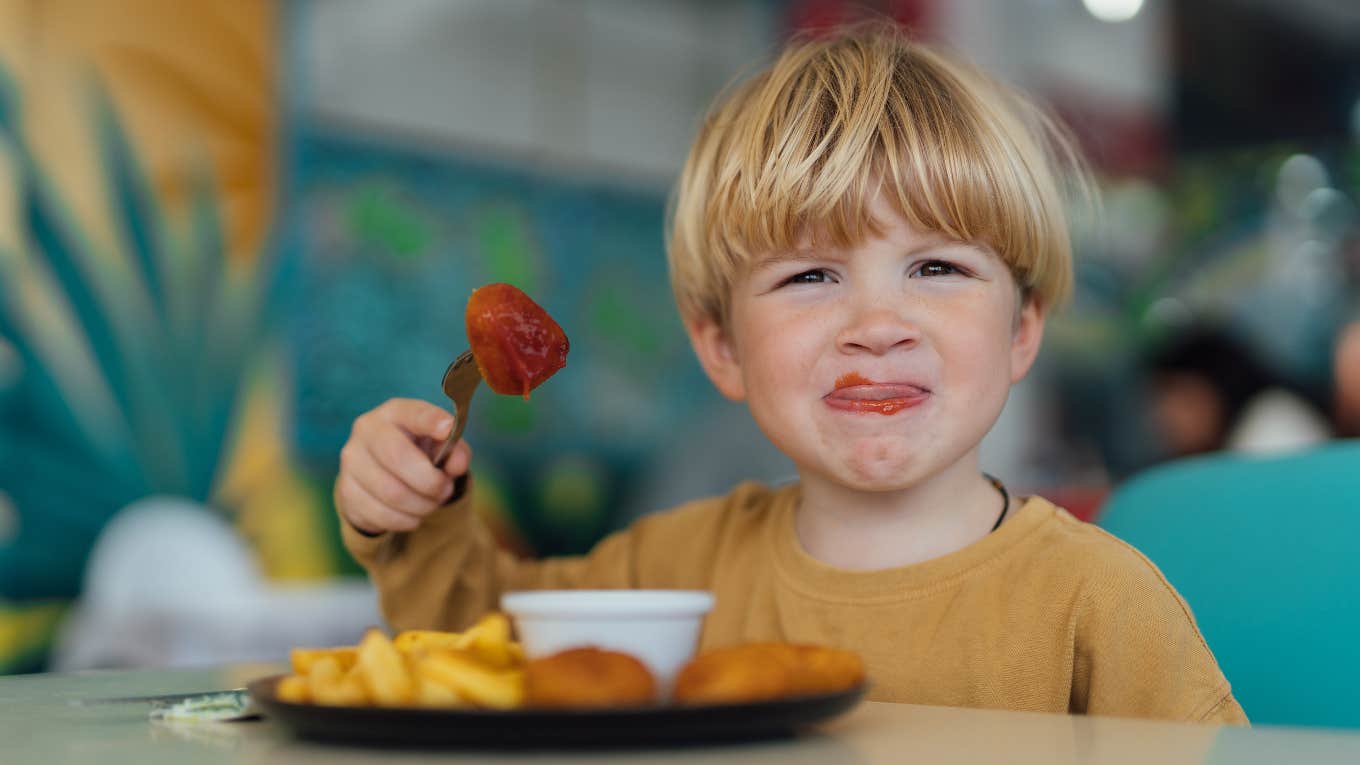 Child eating food with ketchup