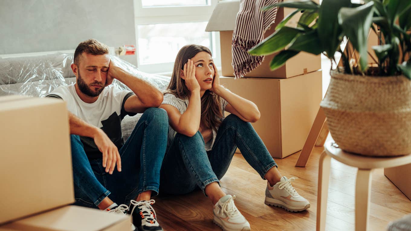 Upset couple surrounded by clutter in their home. 