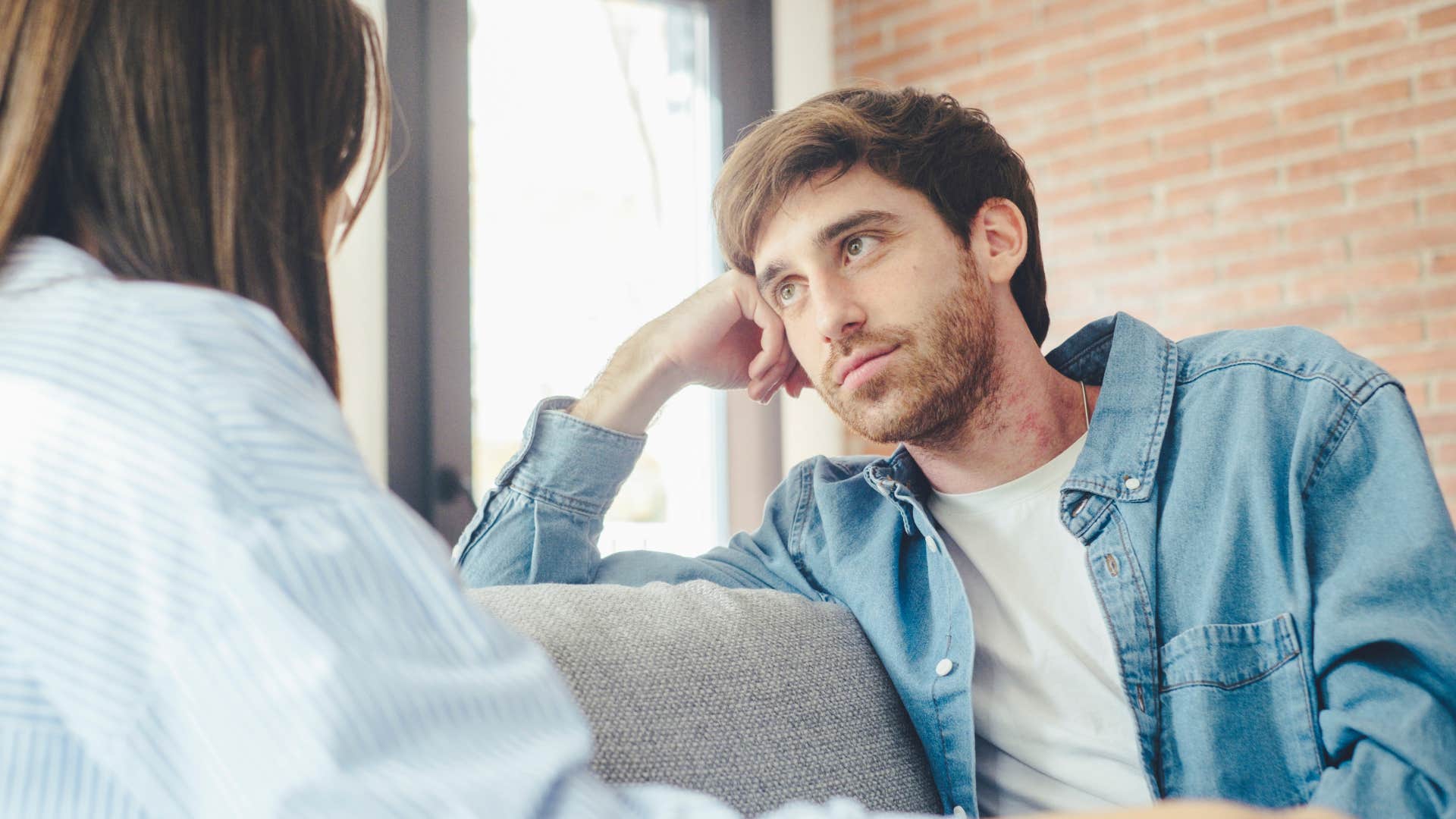 Man looking at his girlfriend on the couch.