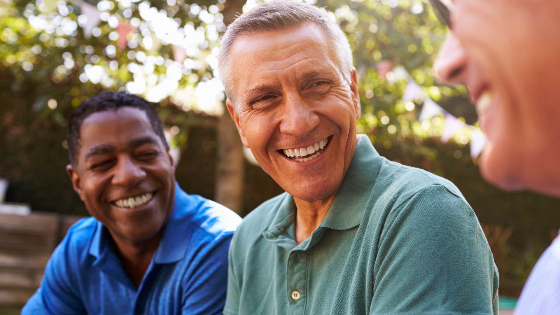 Two old men laughing and talking together.