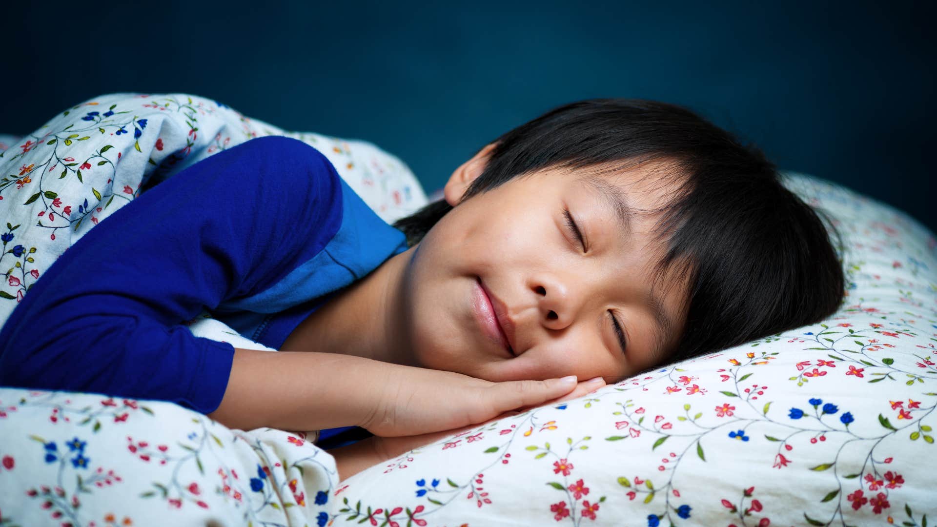 Young boy taking a nap in his bed.