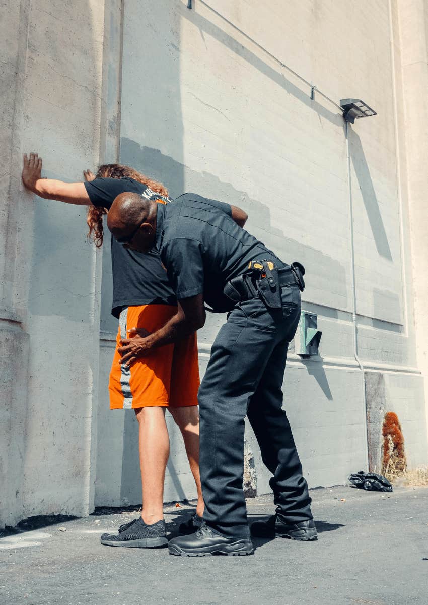 officer patting down a man on the street