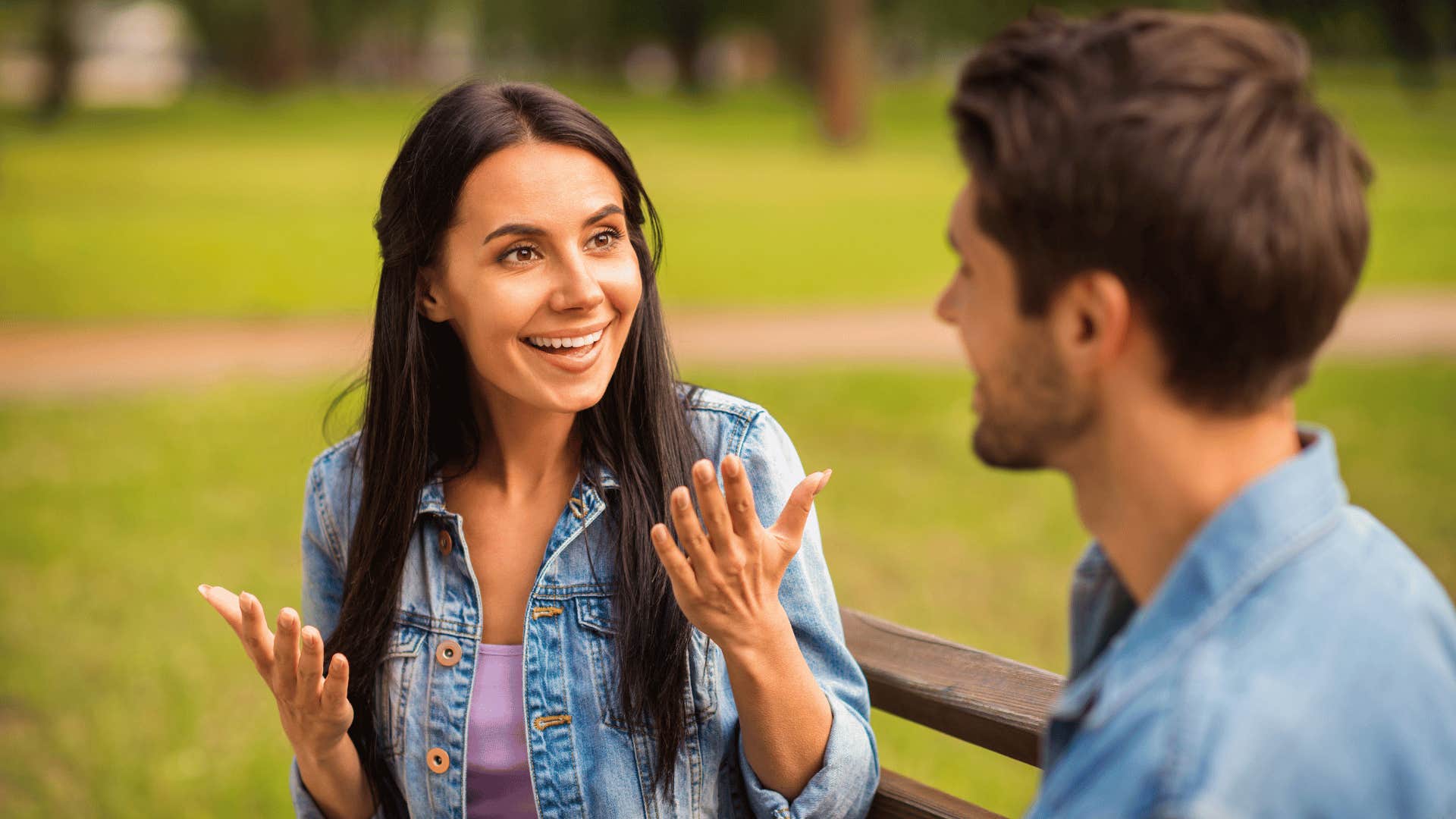 woman speaking to man on bench