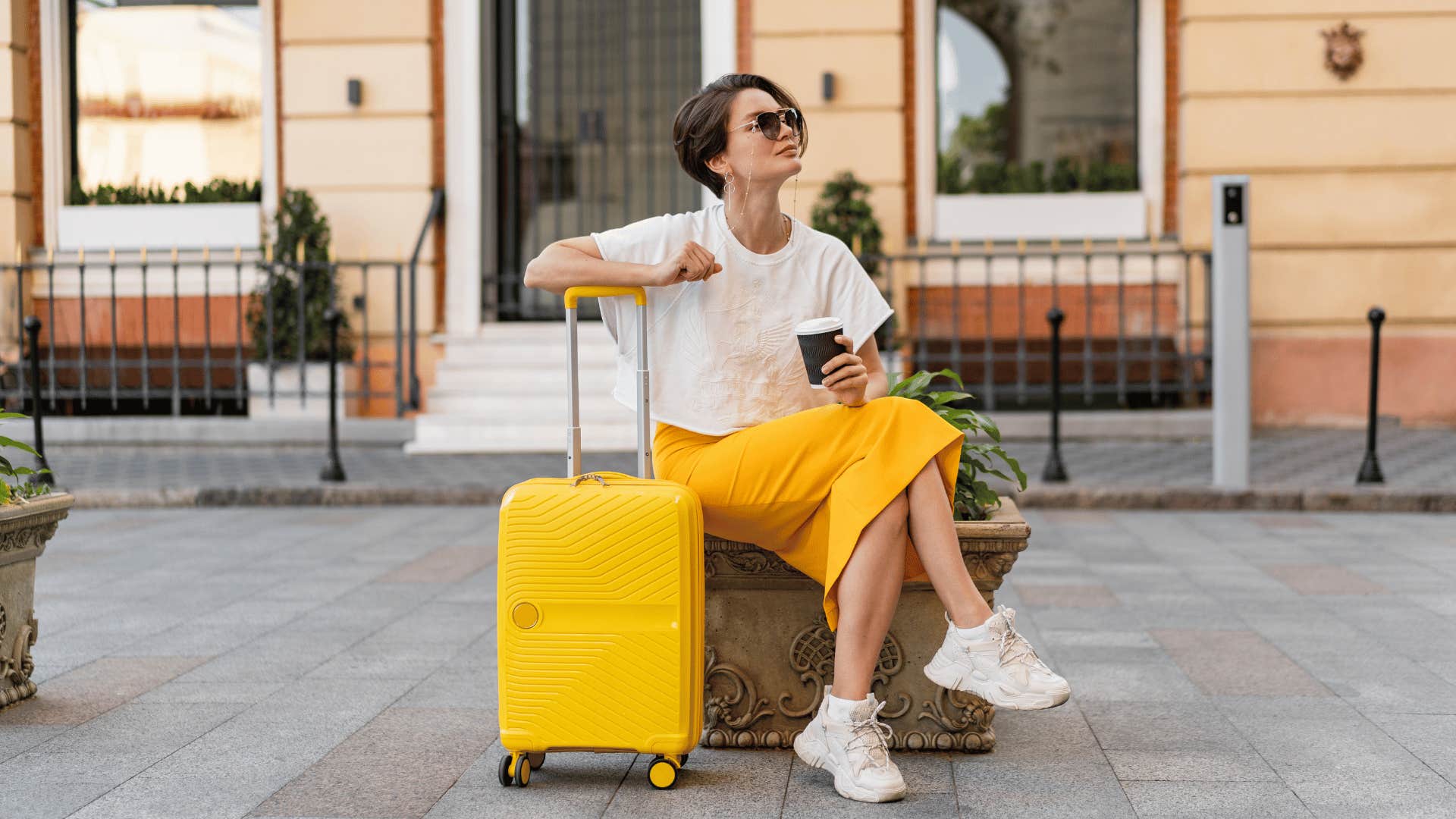 woman sitting on bench with luggage