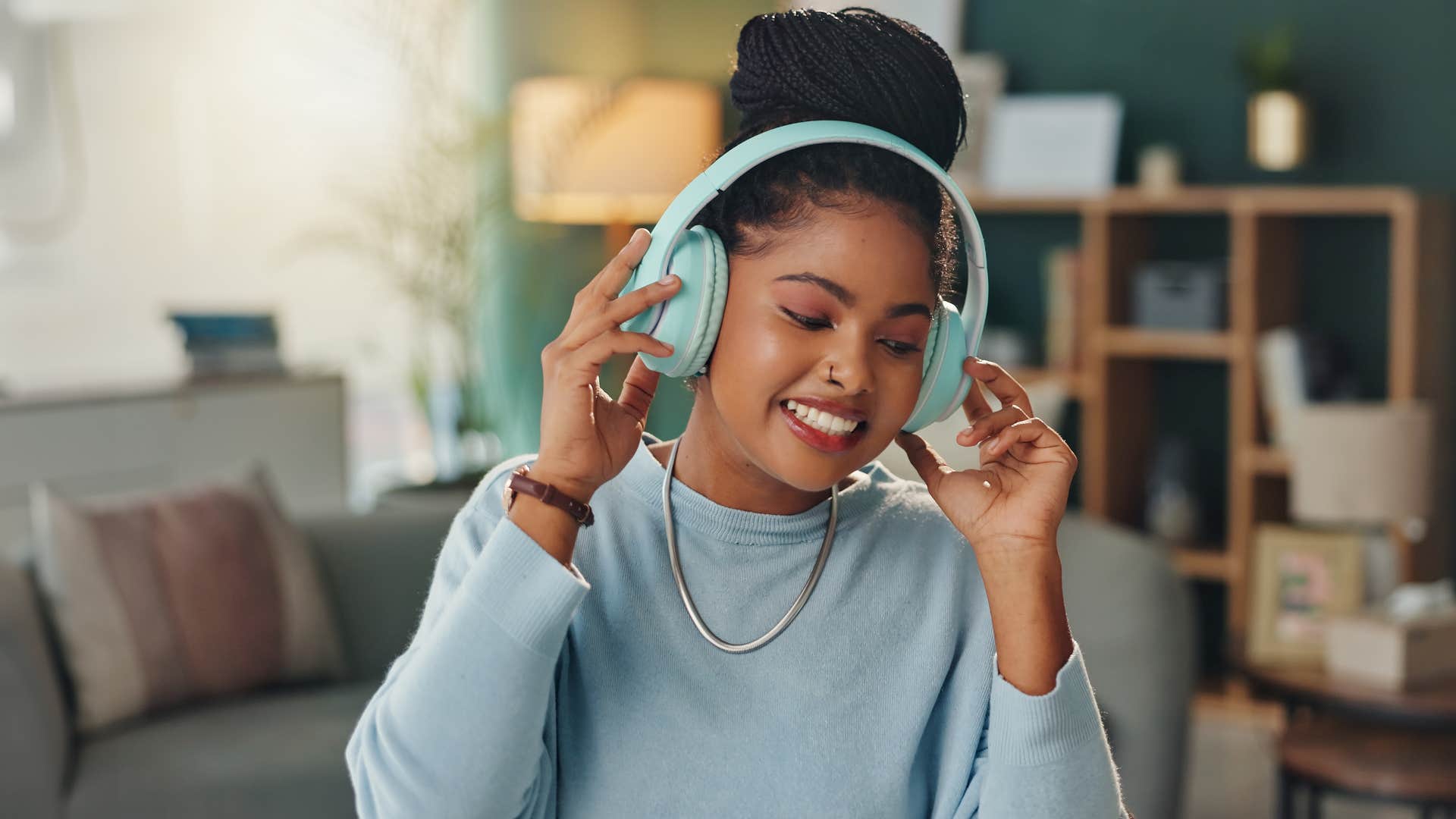 Young woman smiling with big headphones on.