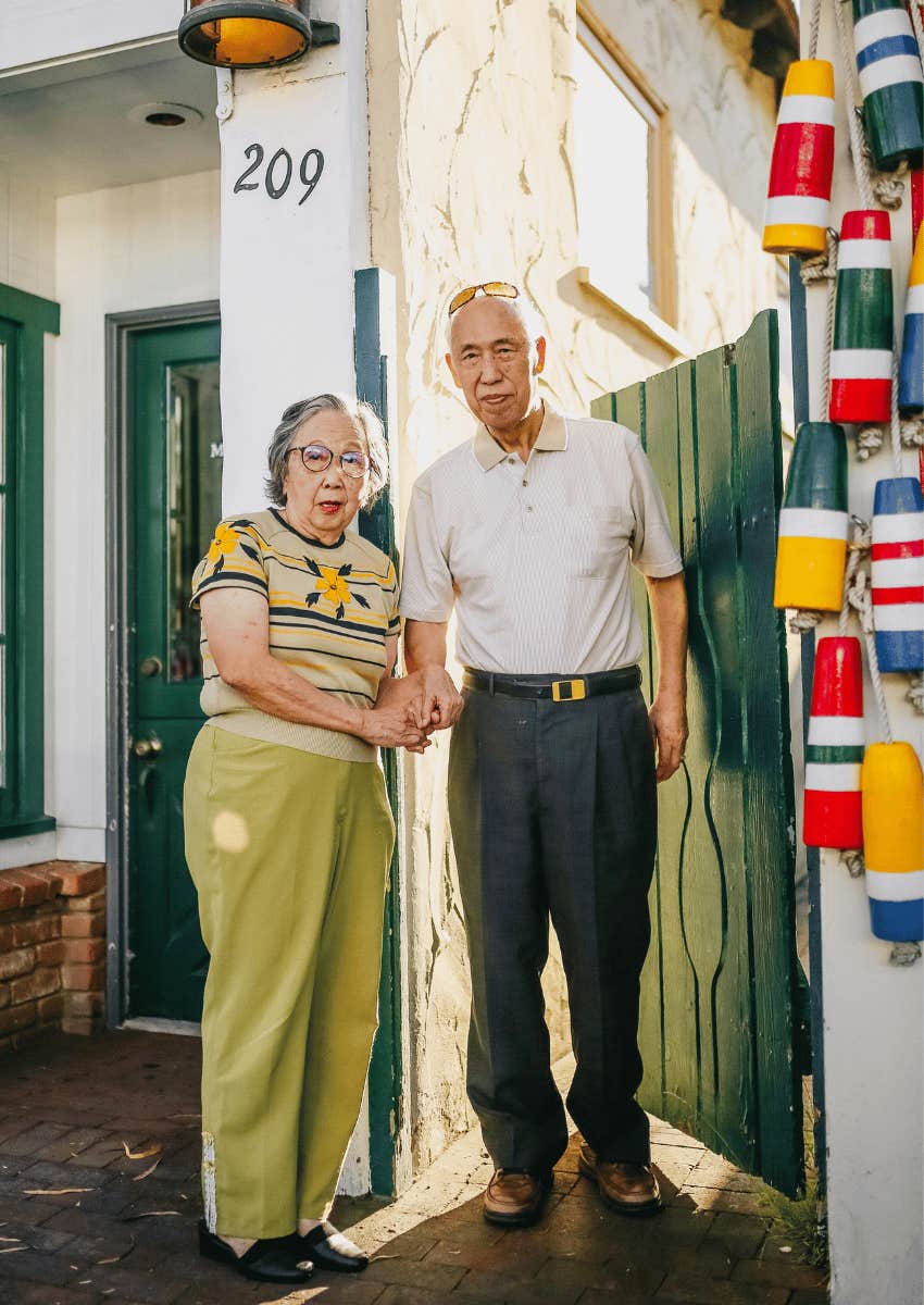 older couple posing next to building