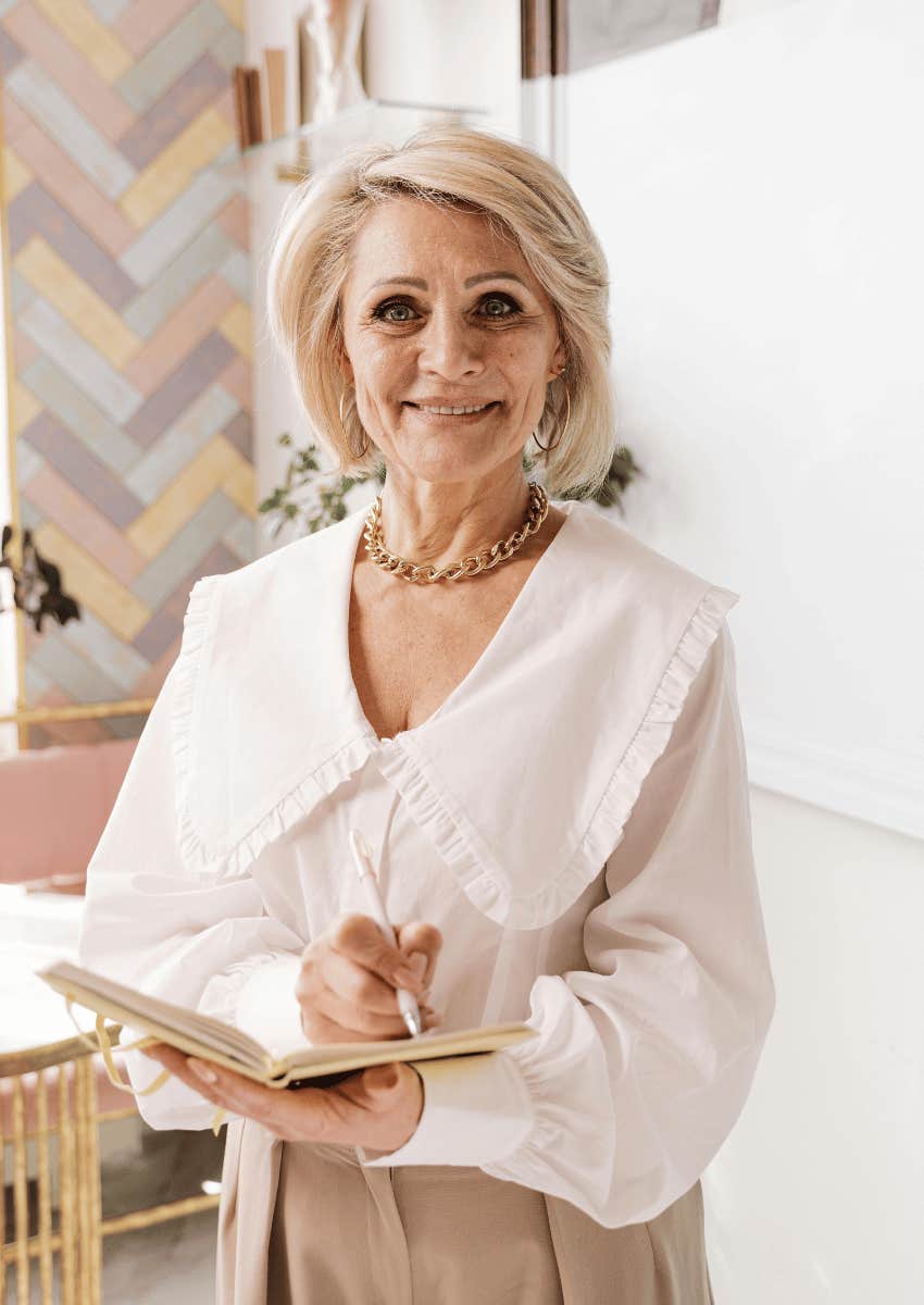 older woman holding an open notebook