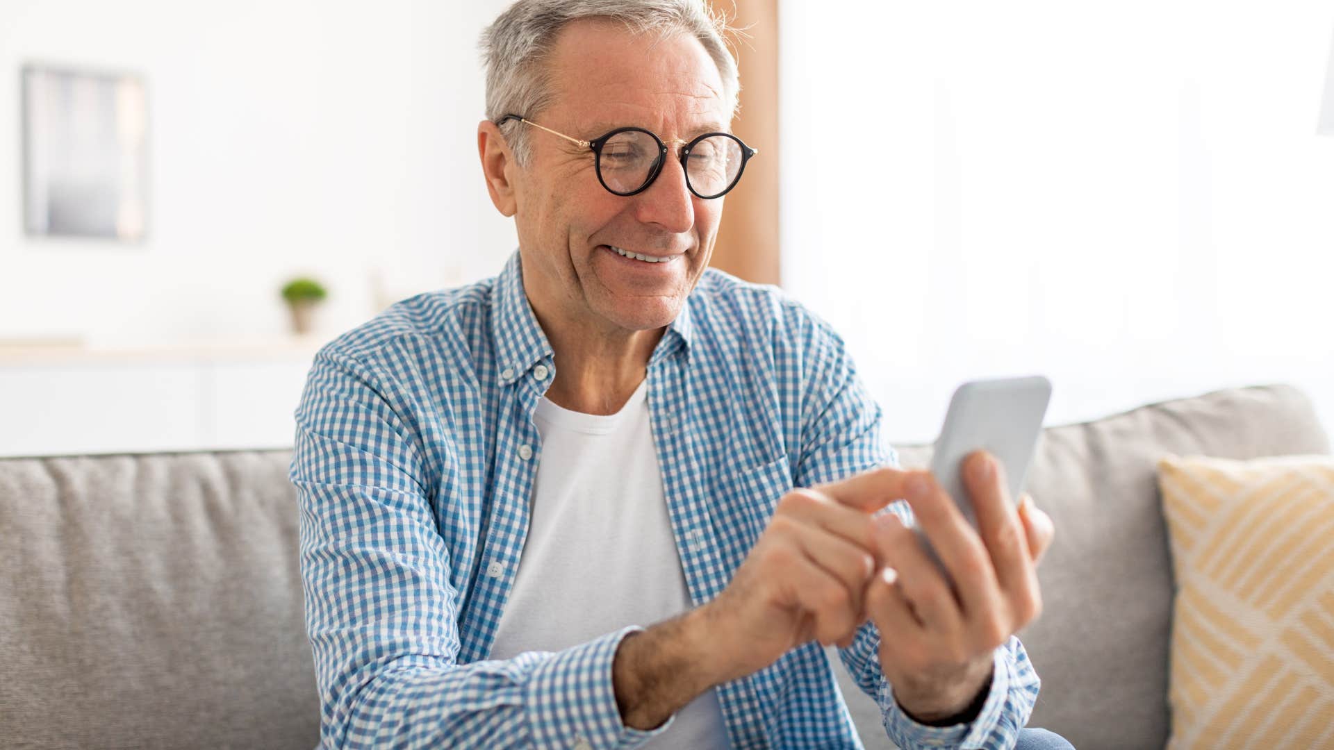 Older man texting on his phone.