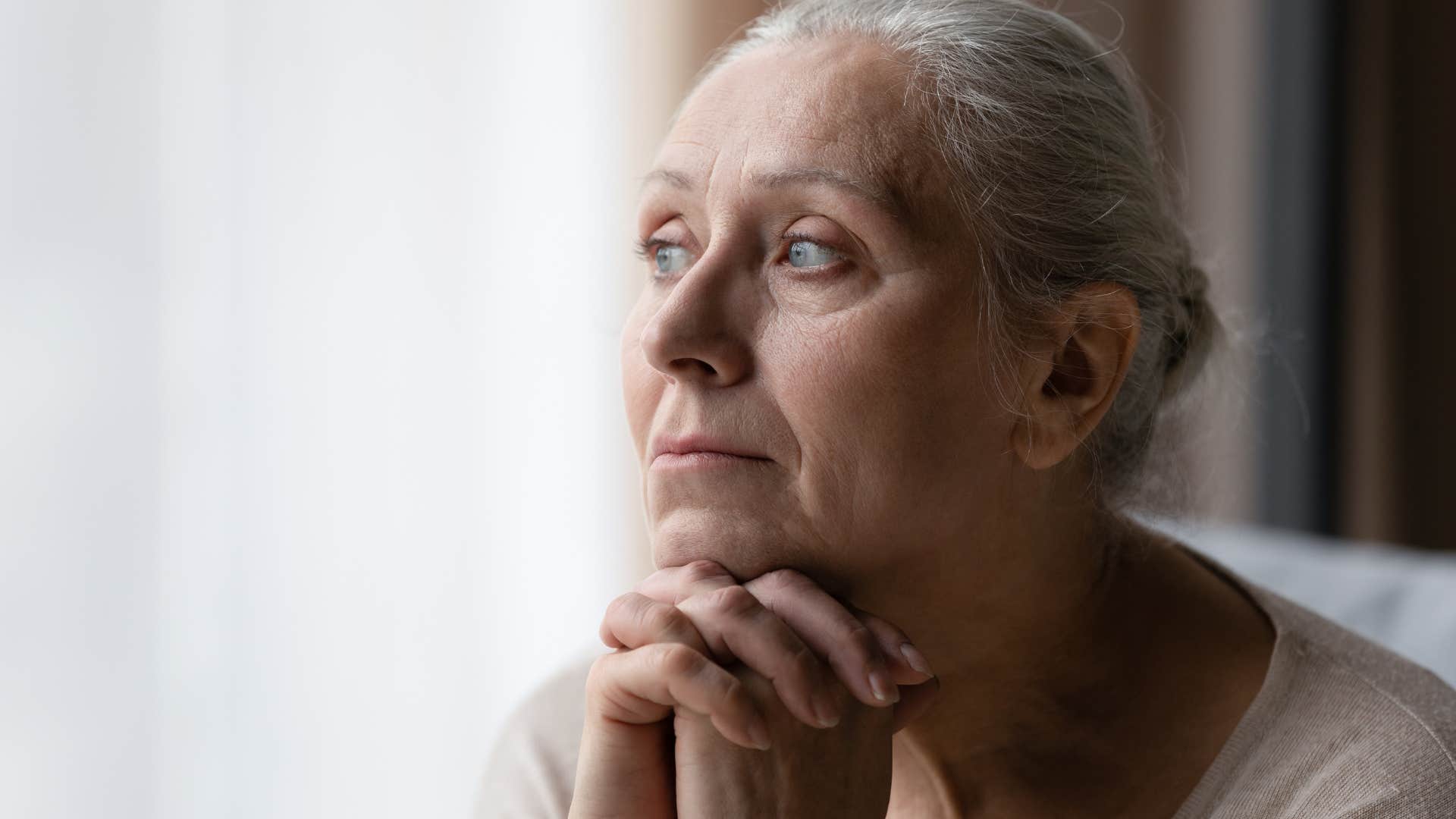 Older woman looking sad and lonely at home.