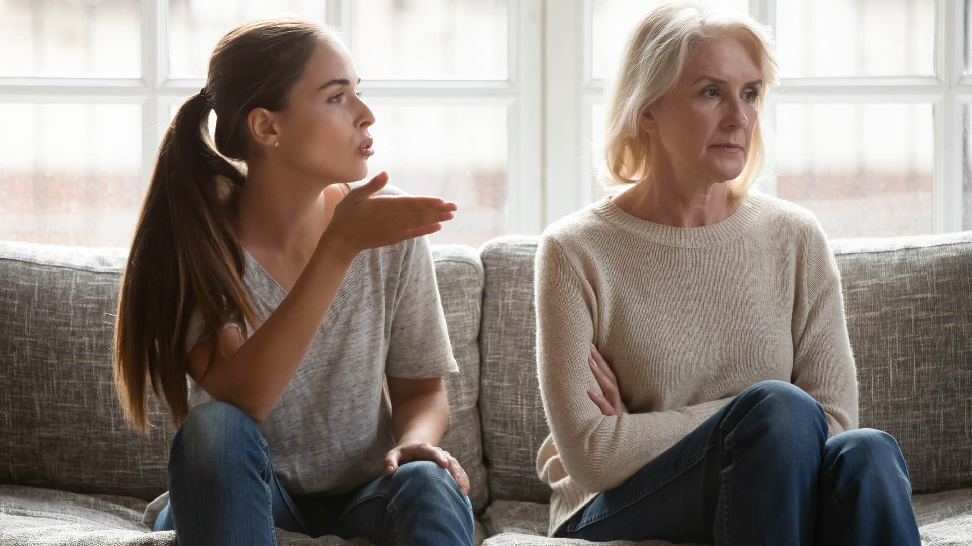 Adult daughter yelling at her mom on the couch.