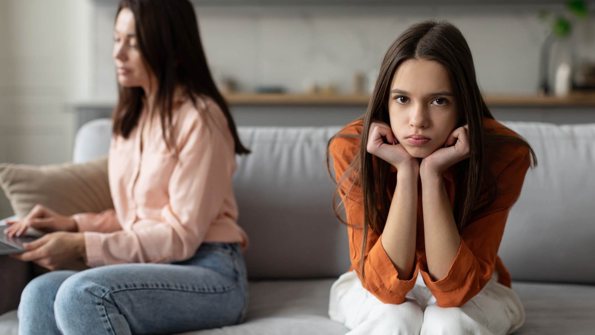 Teenage daughter looking annoyed next to her mom.