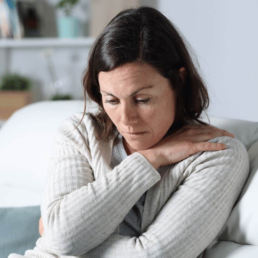 pensive woman hugging herself