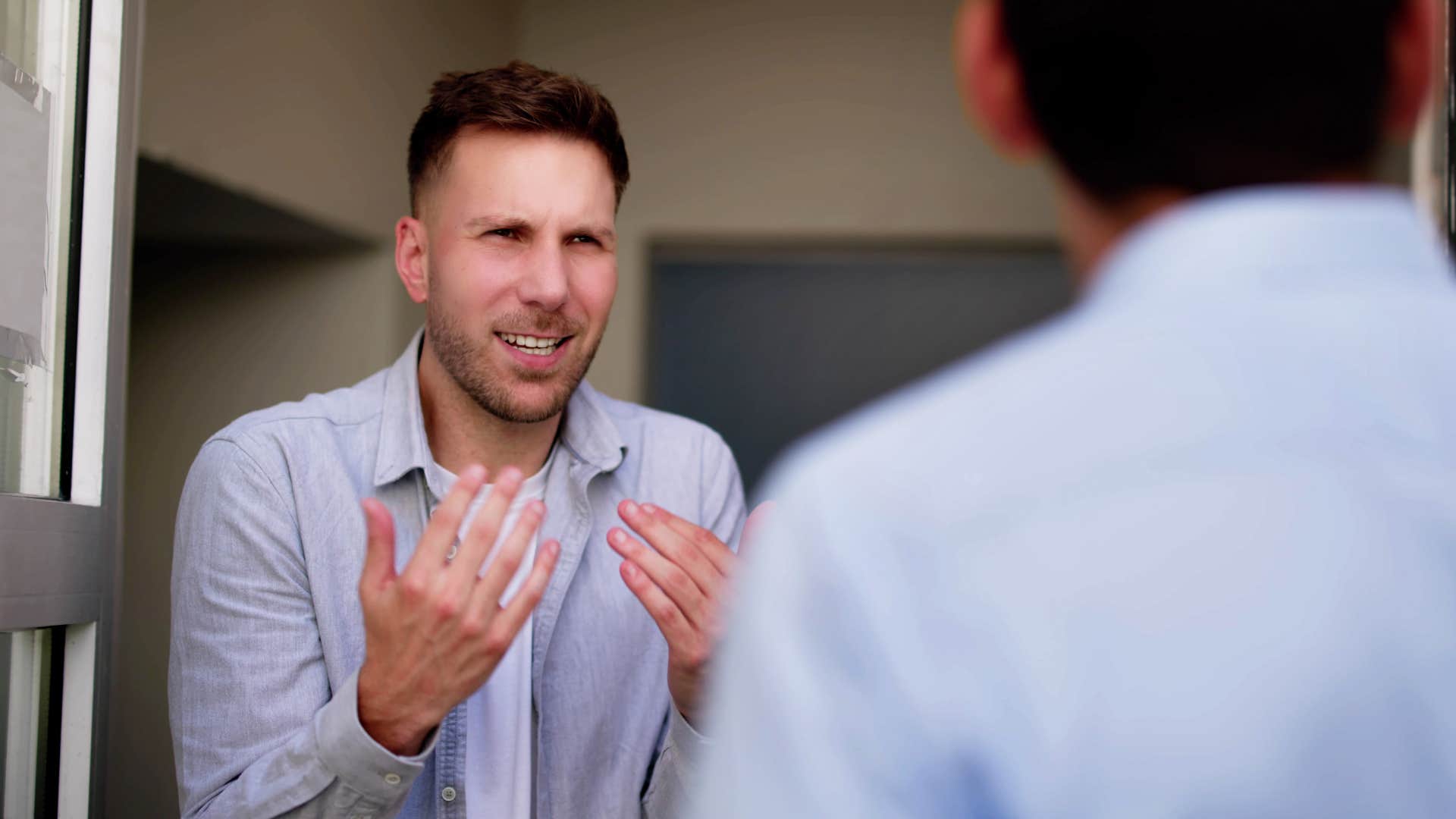 Man looking annoyed talking to his friend.