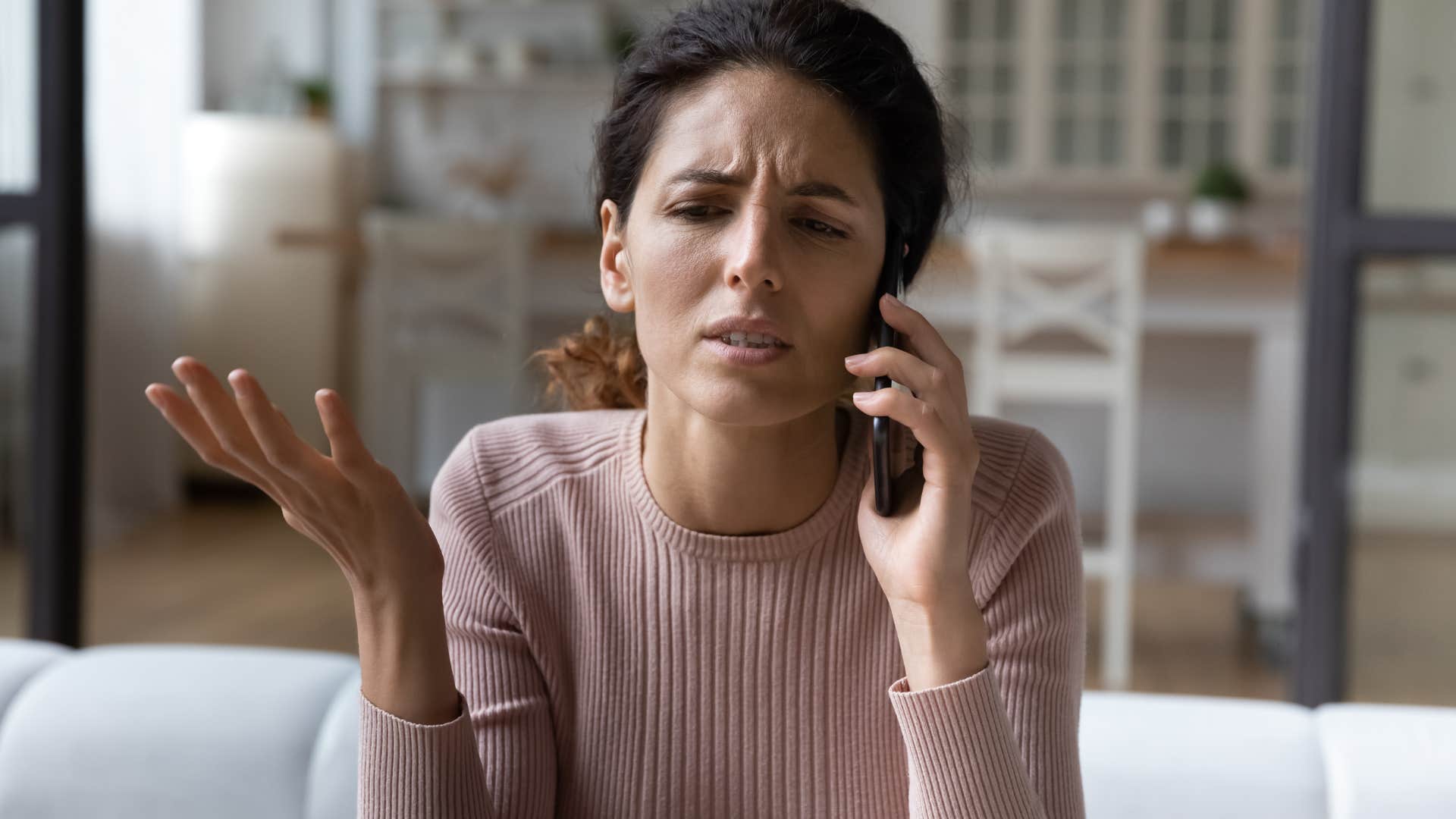 Woman looking annoyed while talking on the phone.