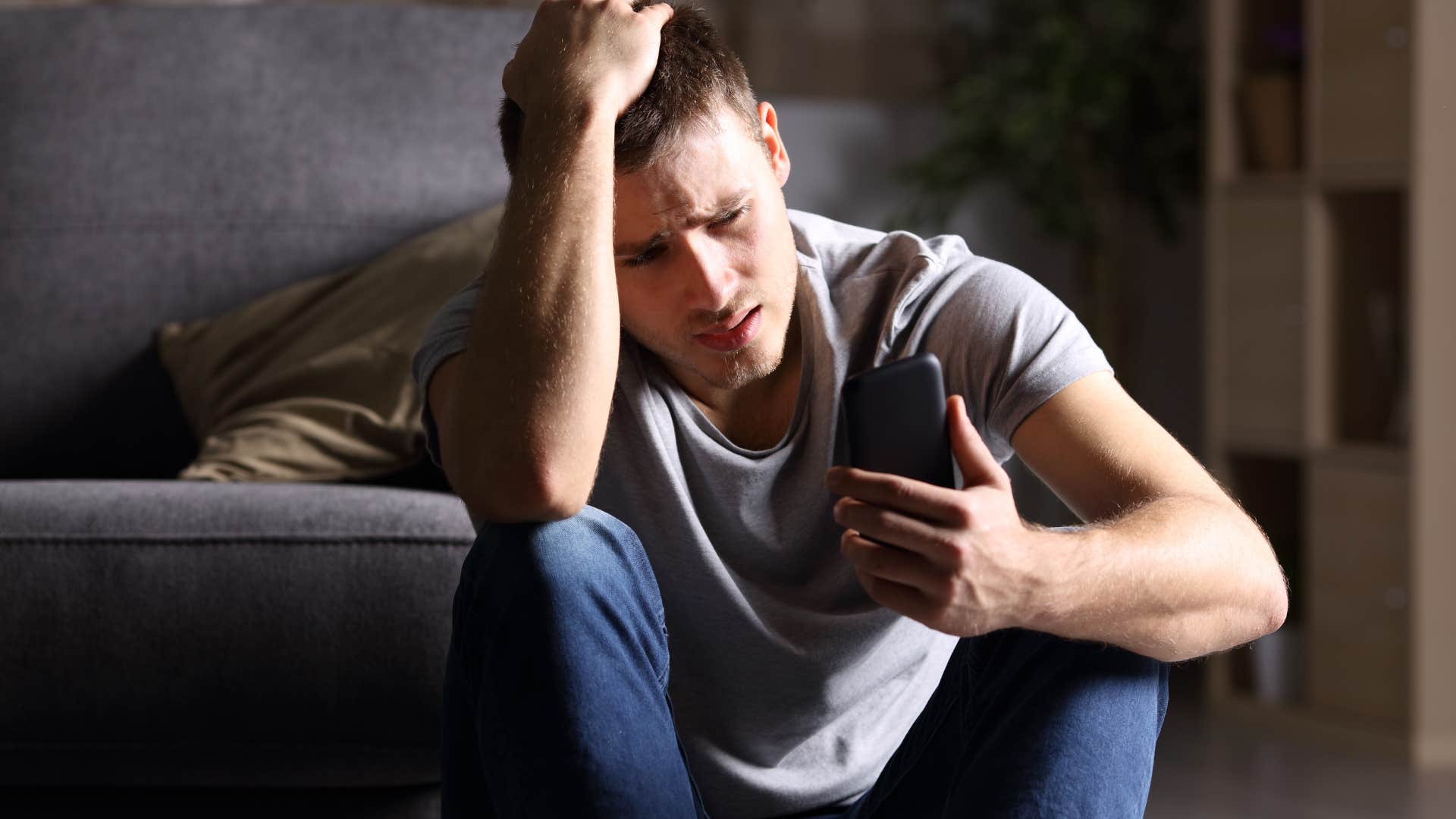 Man looking stressed at his phone. 