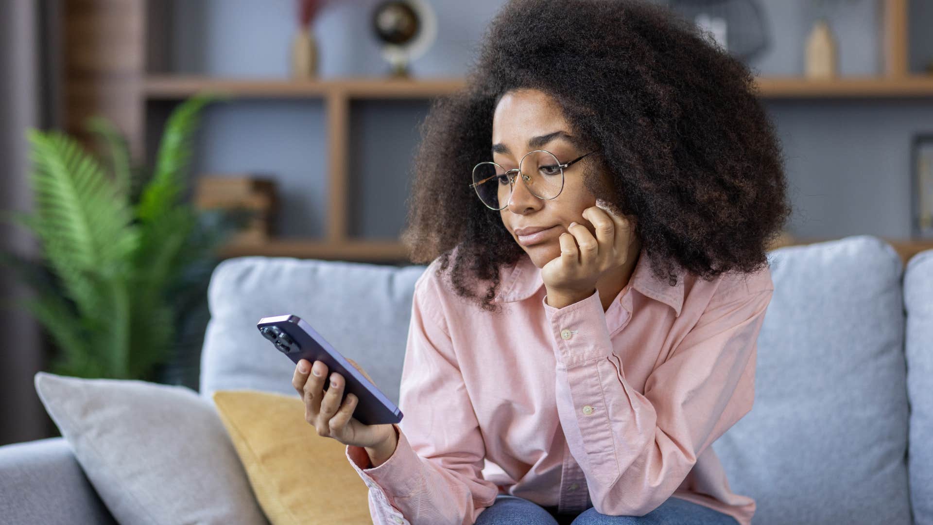 Woman looking sad while staring at her phone.