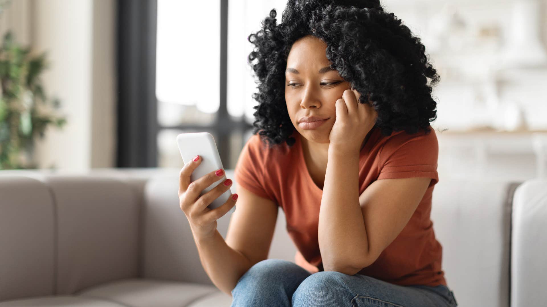 Woman looking upset staring at her phone. 