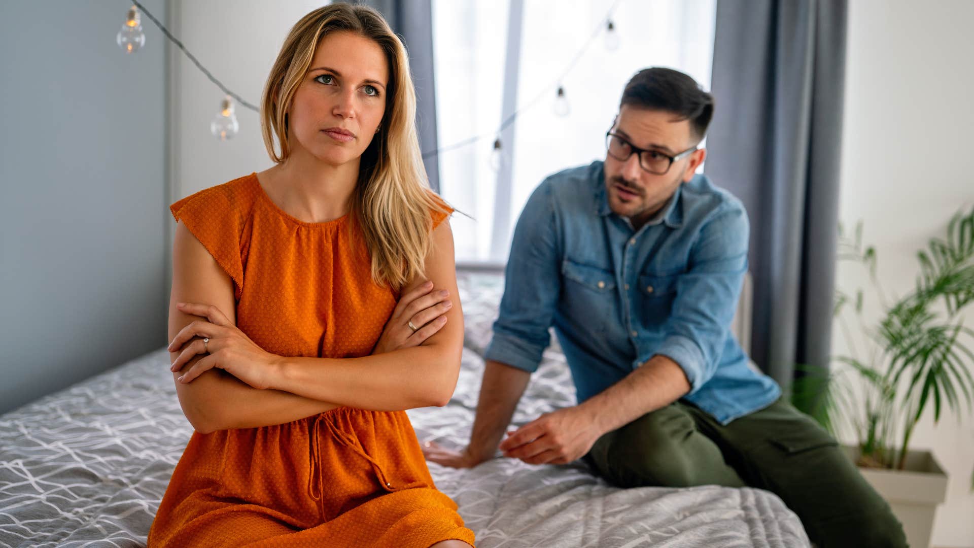 Woman crossing her arms and sitting away from her boyfriend.