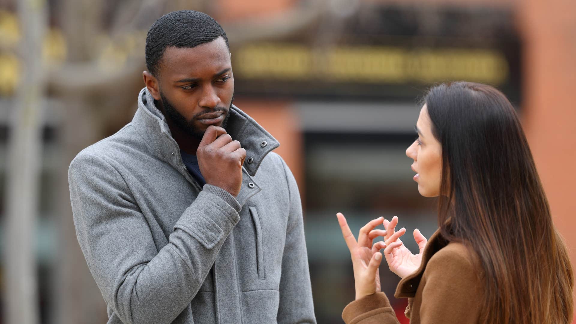 Man looking upset standing in front of his girlfriend. 