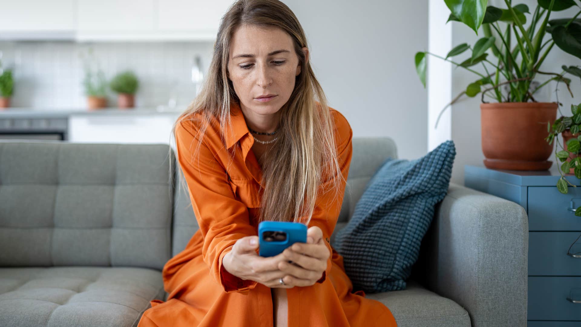 Woman looking sadly at her cell phone. 