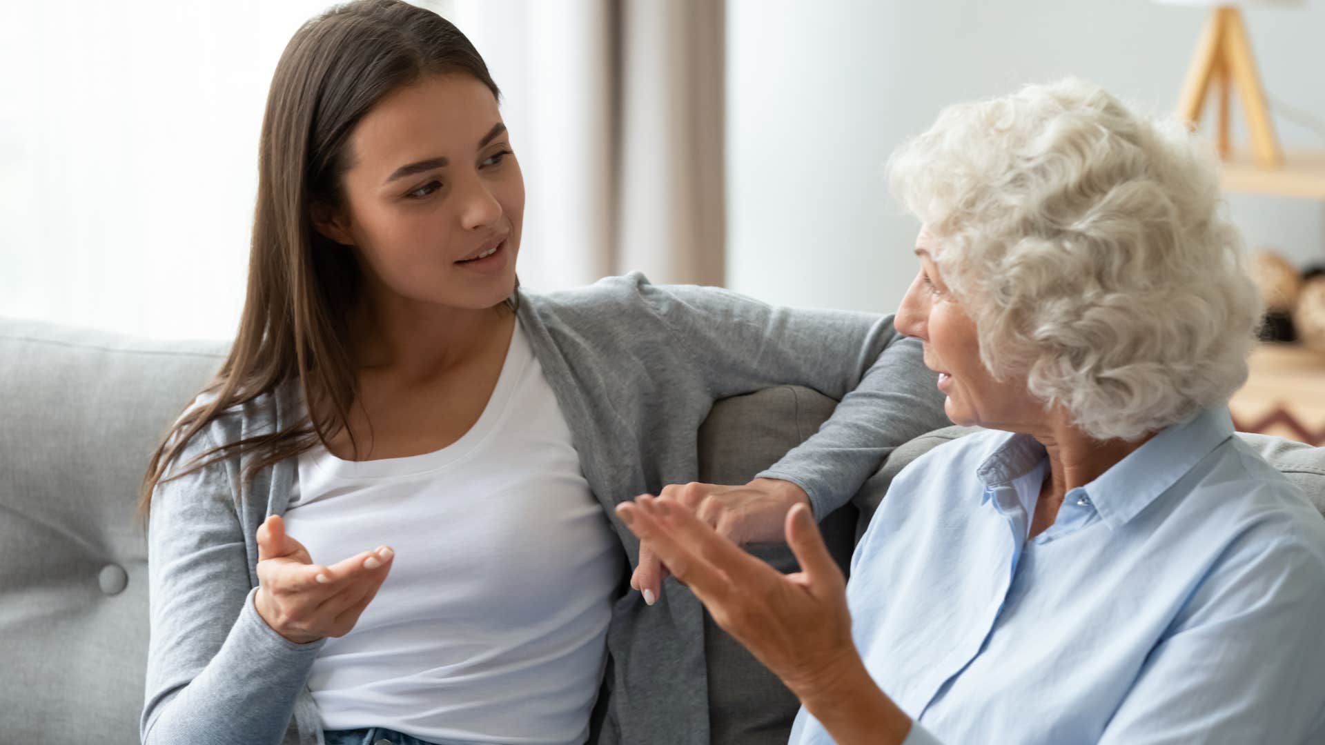 Woman looking annoyed while talking to her mom on the couch