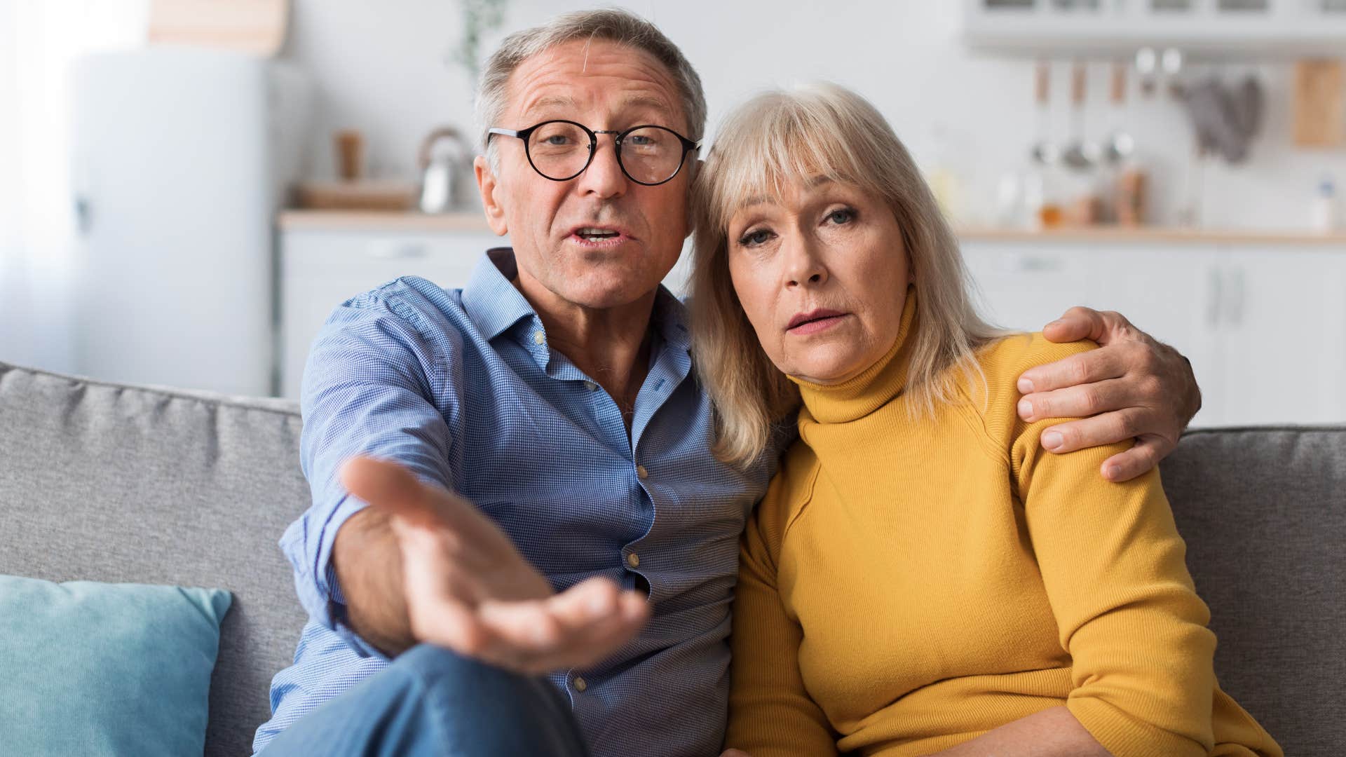 Adult parents looking concerned on the couch