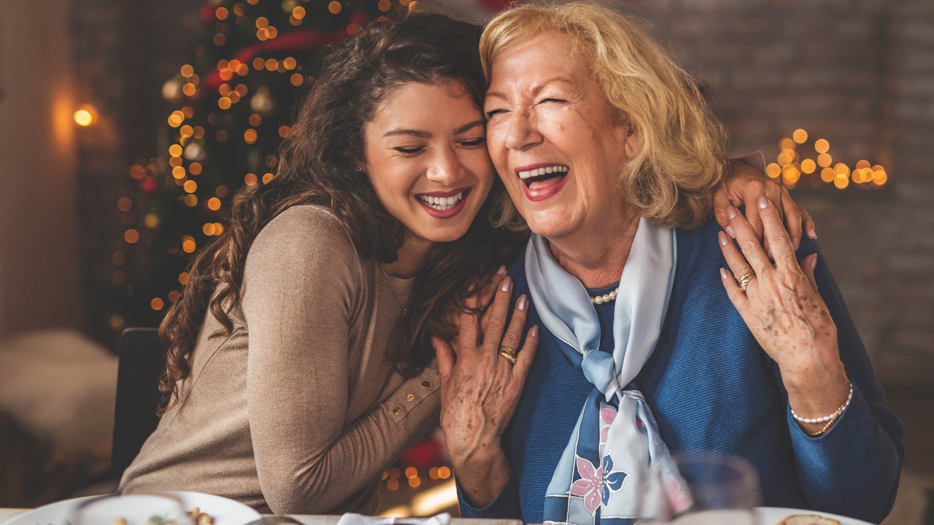 Woman hugging an older woman at a holiday dinner.