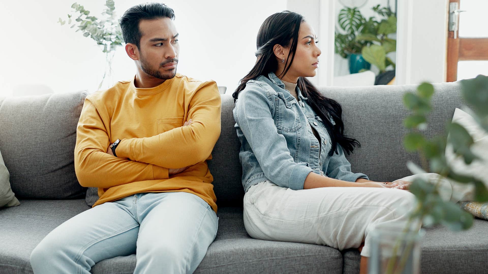 Woman turned away from her upset partner on the couch.