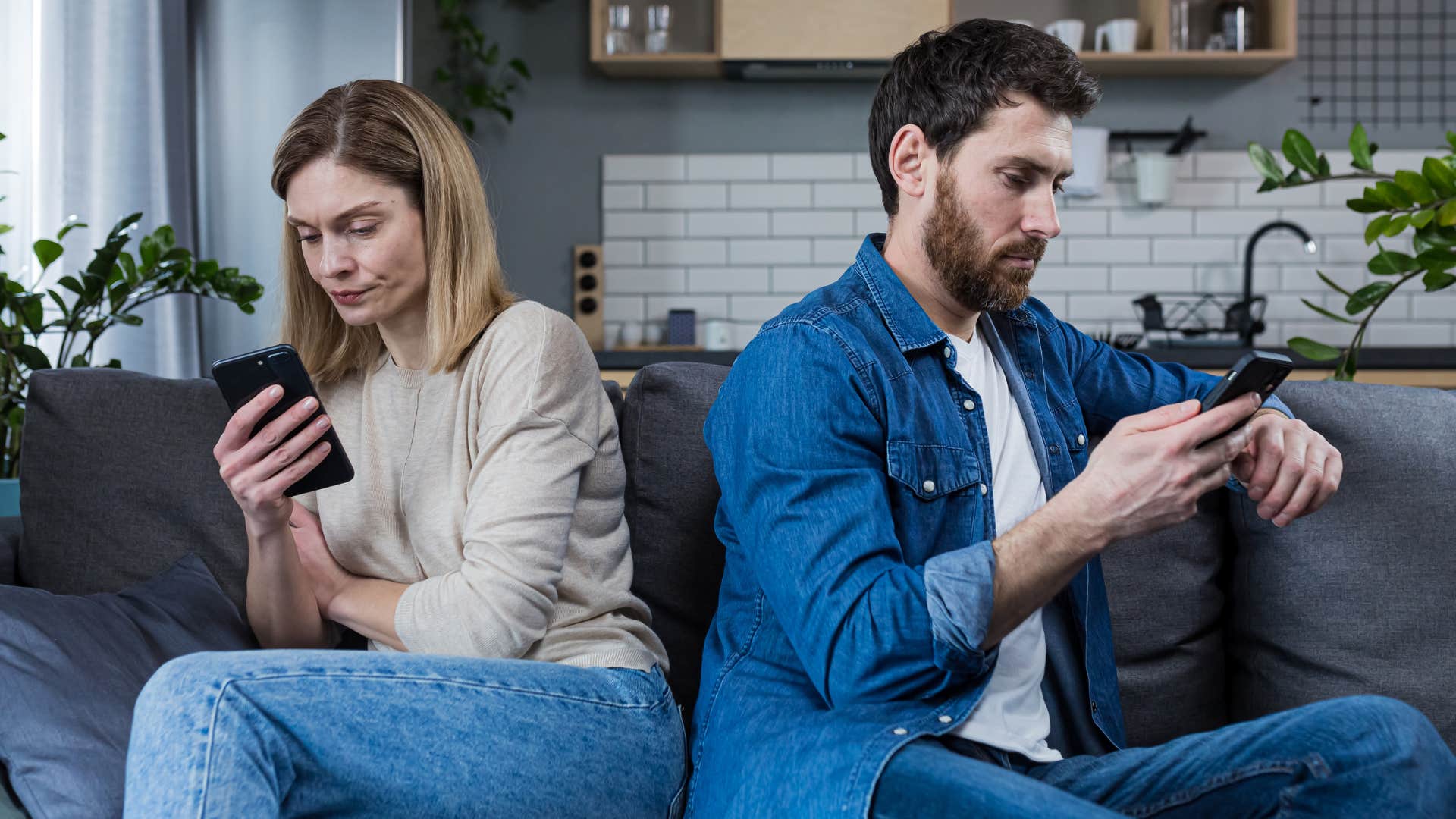 Couple sitting away from each other on their phones.