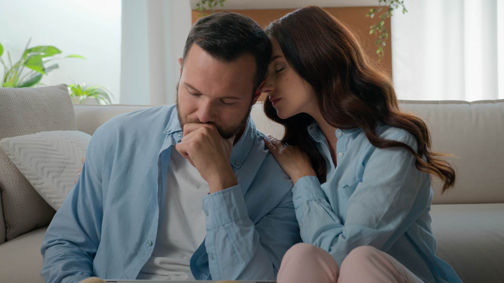 Woman hugging her partner on the couch.