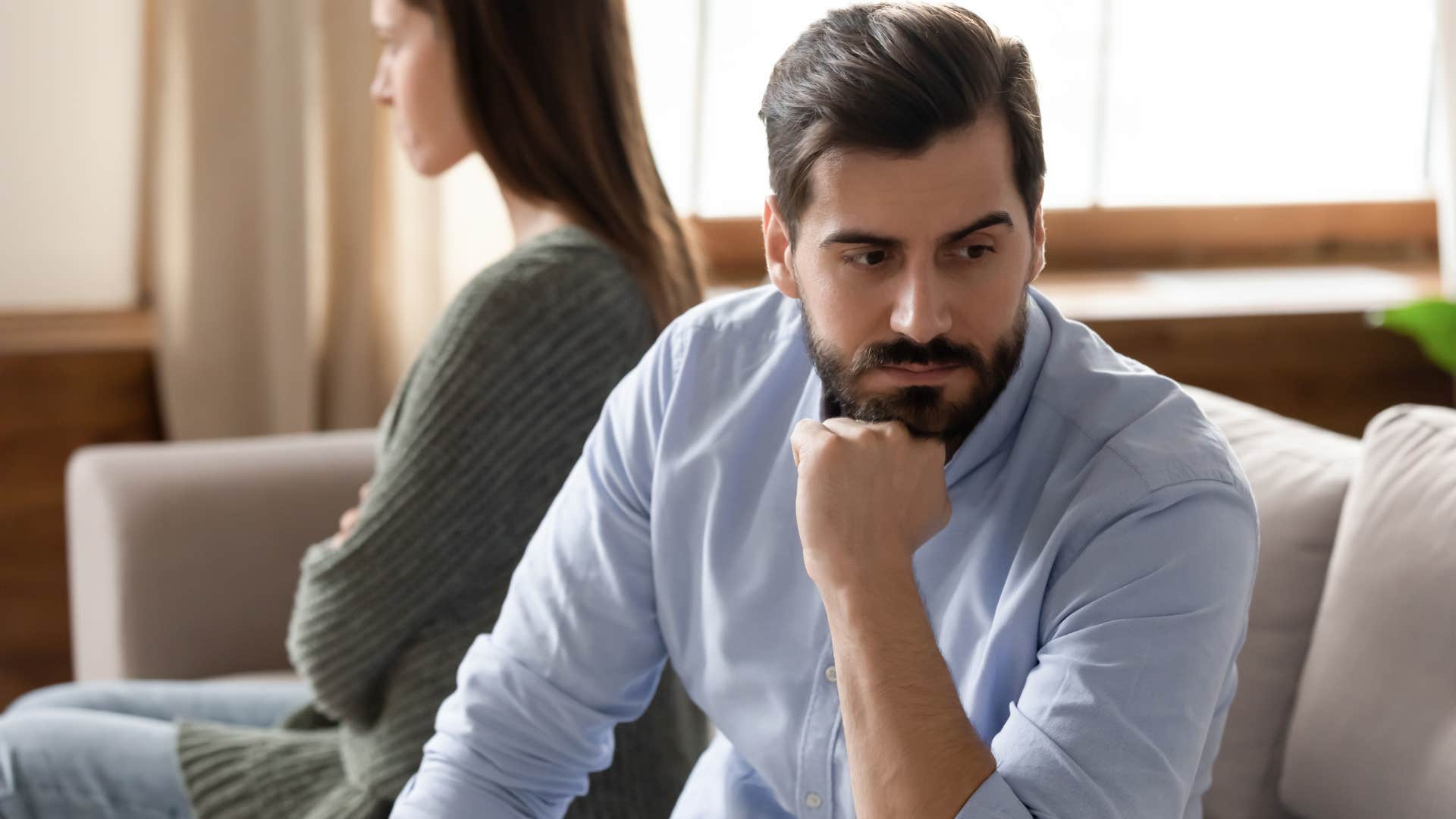 Man turned away from his partner looking upset.