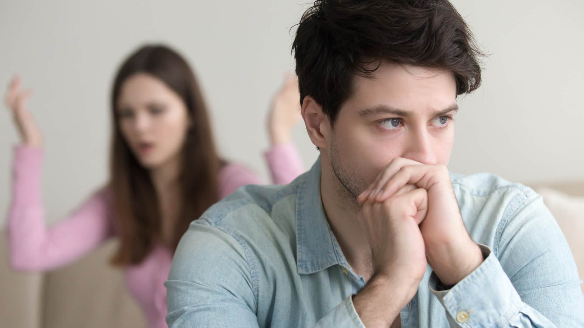 Man looking upset in front of partner.