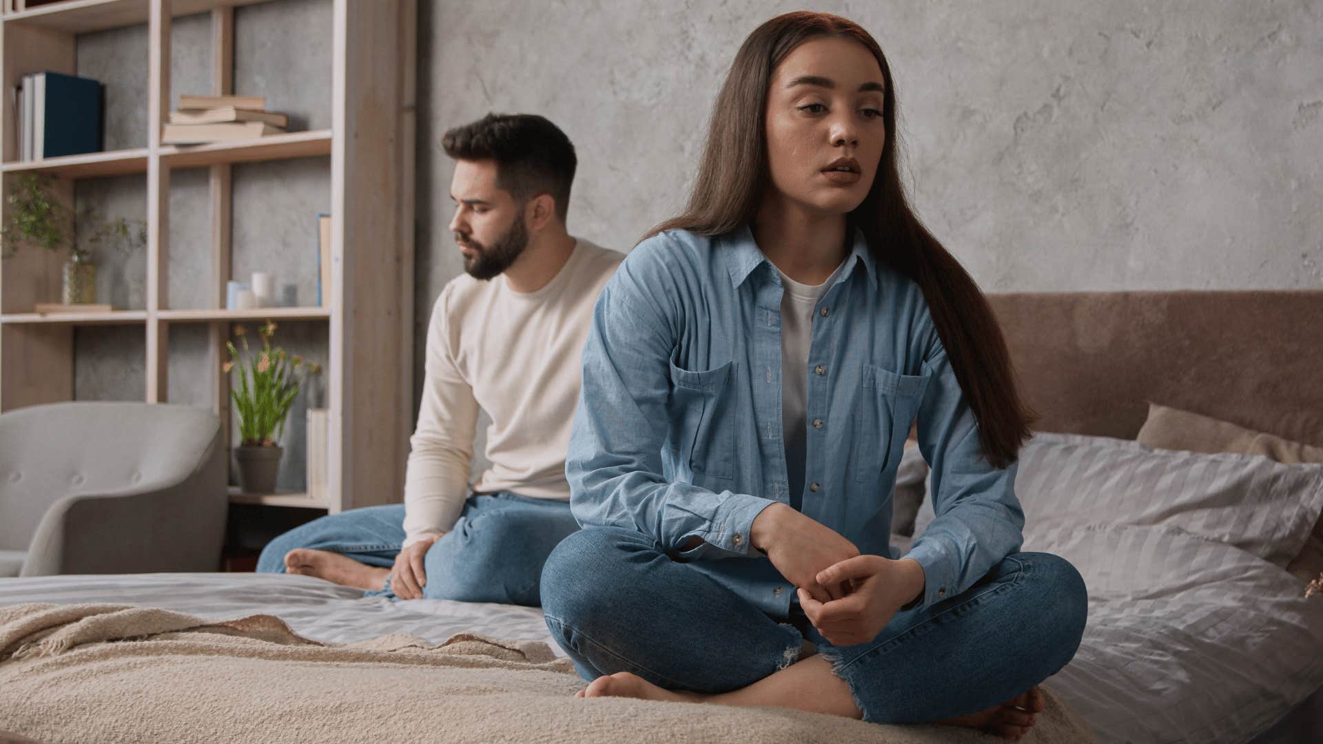 sad woman and husband sitting on bed