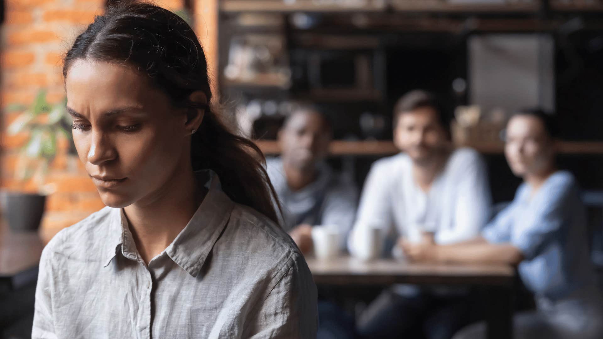 woman staring down while group of people stare at her