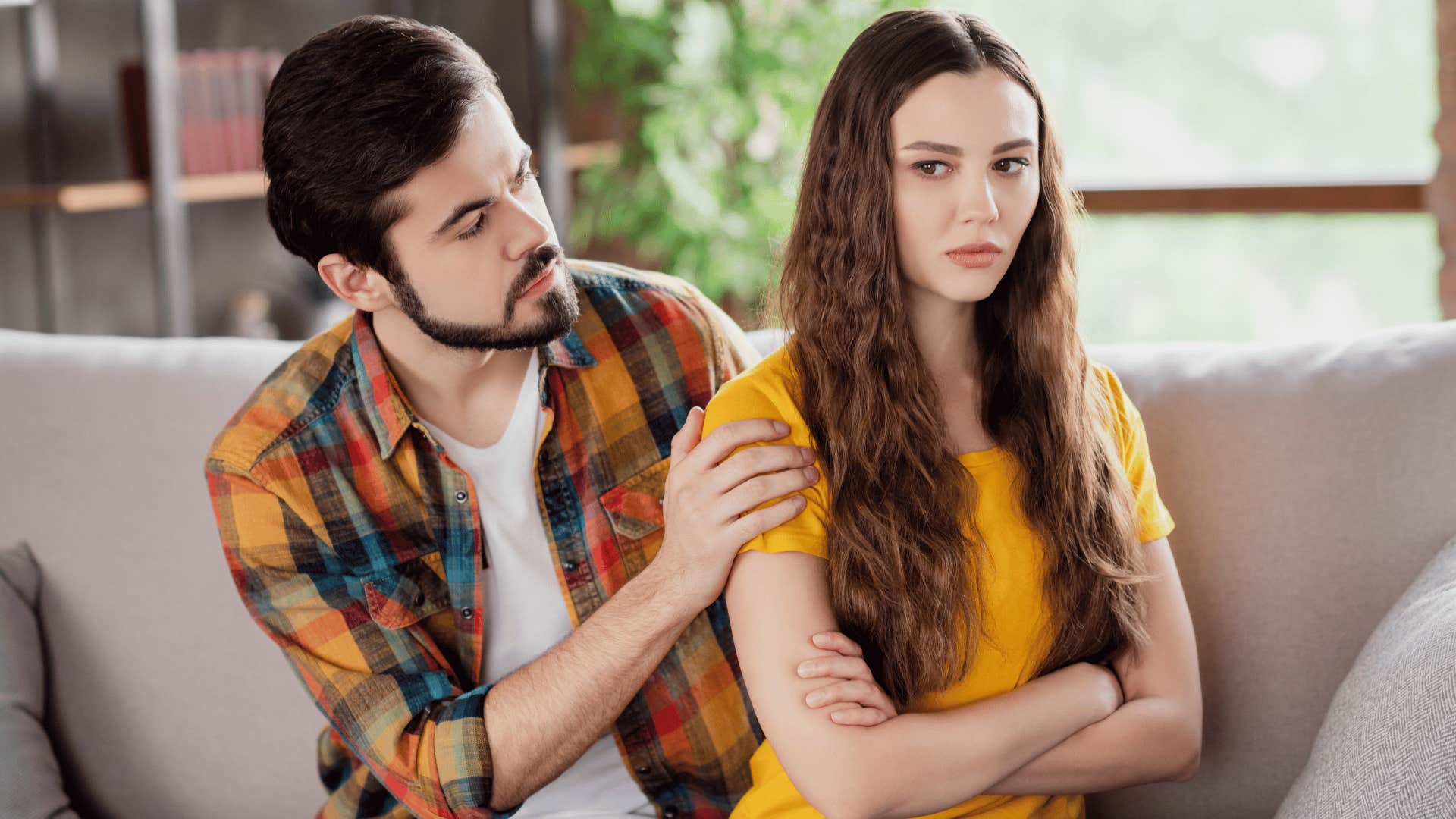 man comforting upset woman while she tries to ignore him 