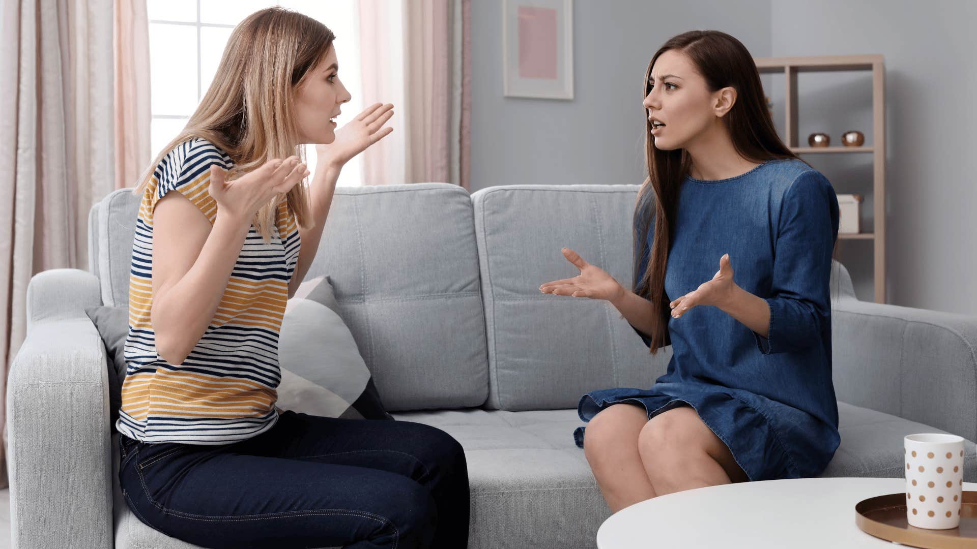 two women arguing and sitting across from each other on couch