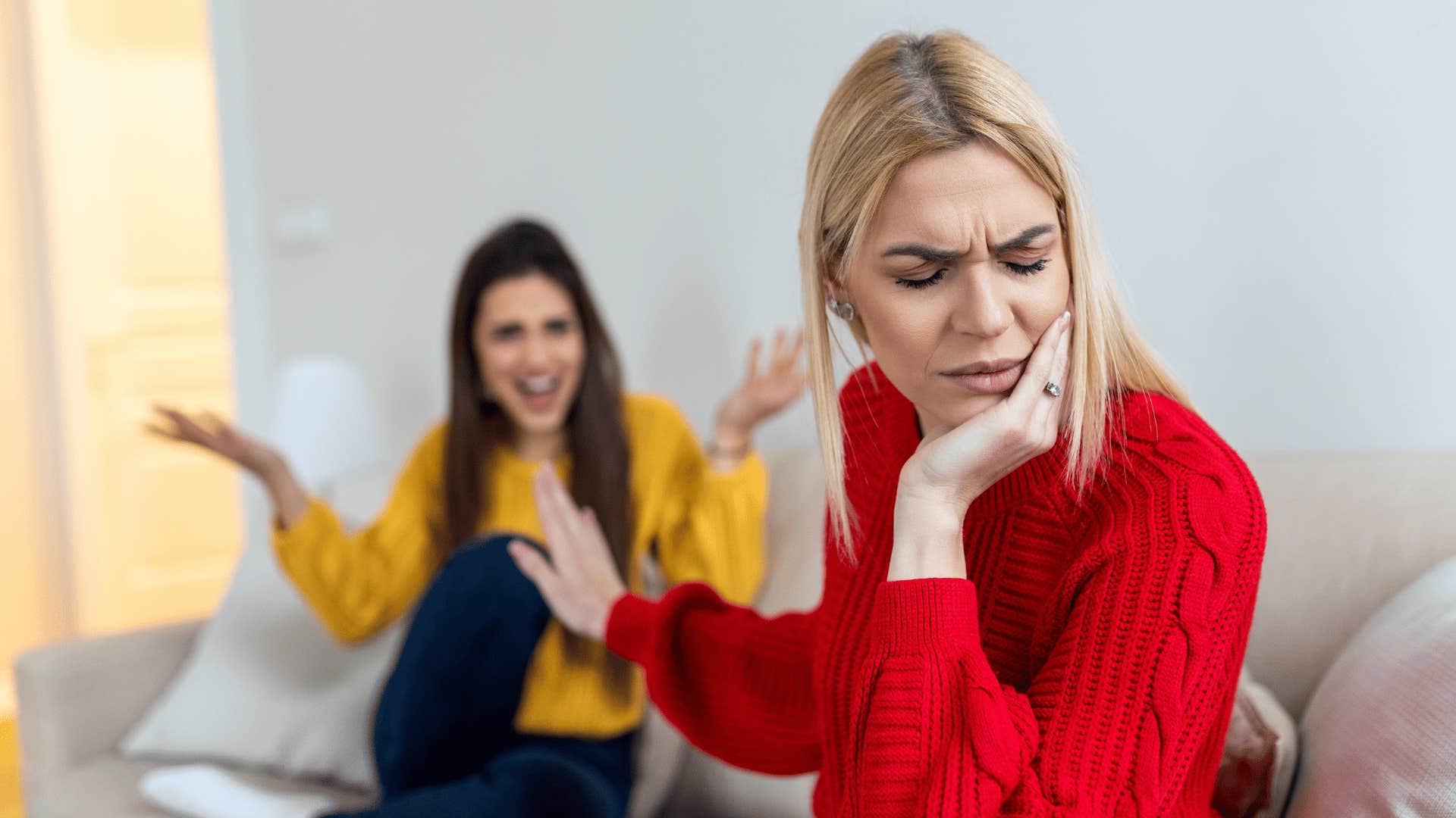 woman holding up hand to other woman