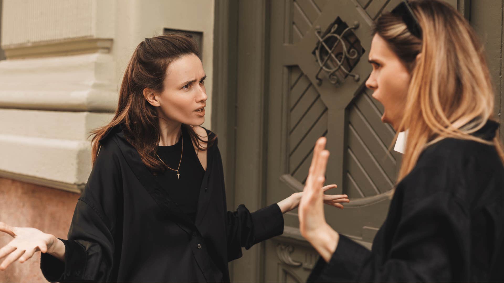 two women arguing outside of building