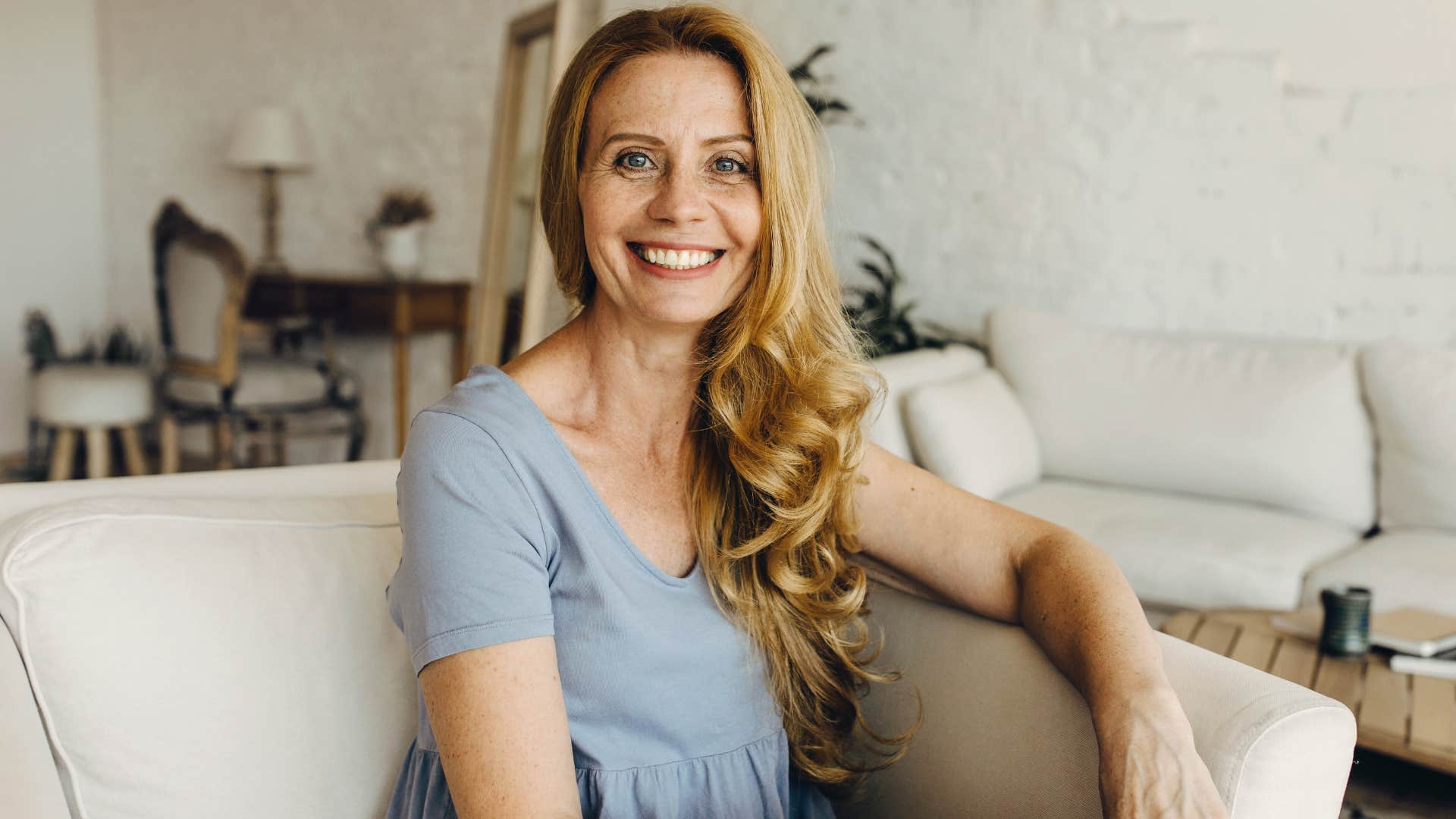 Woman with high IQ smiling while sitting on the couch