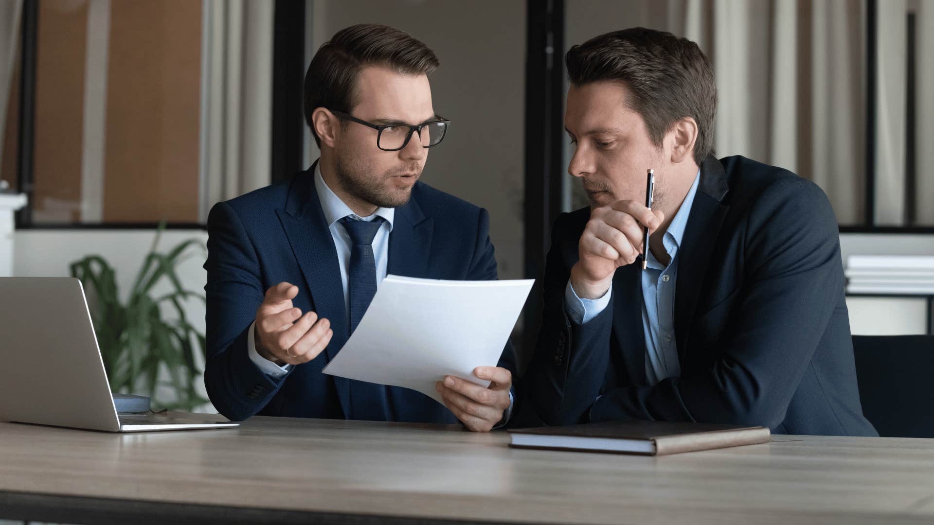 two men talking and looking over paperwork