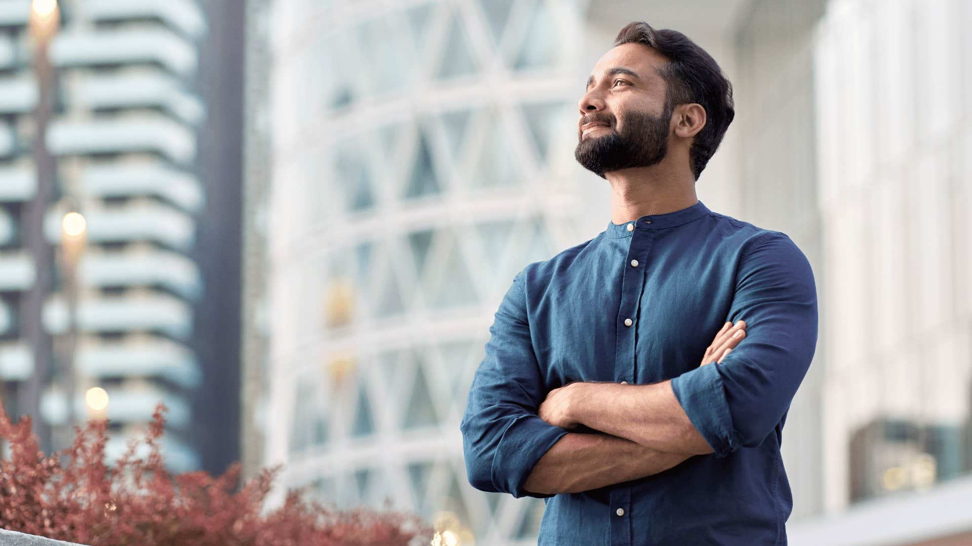 man looking up while crossing arms 