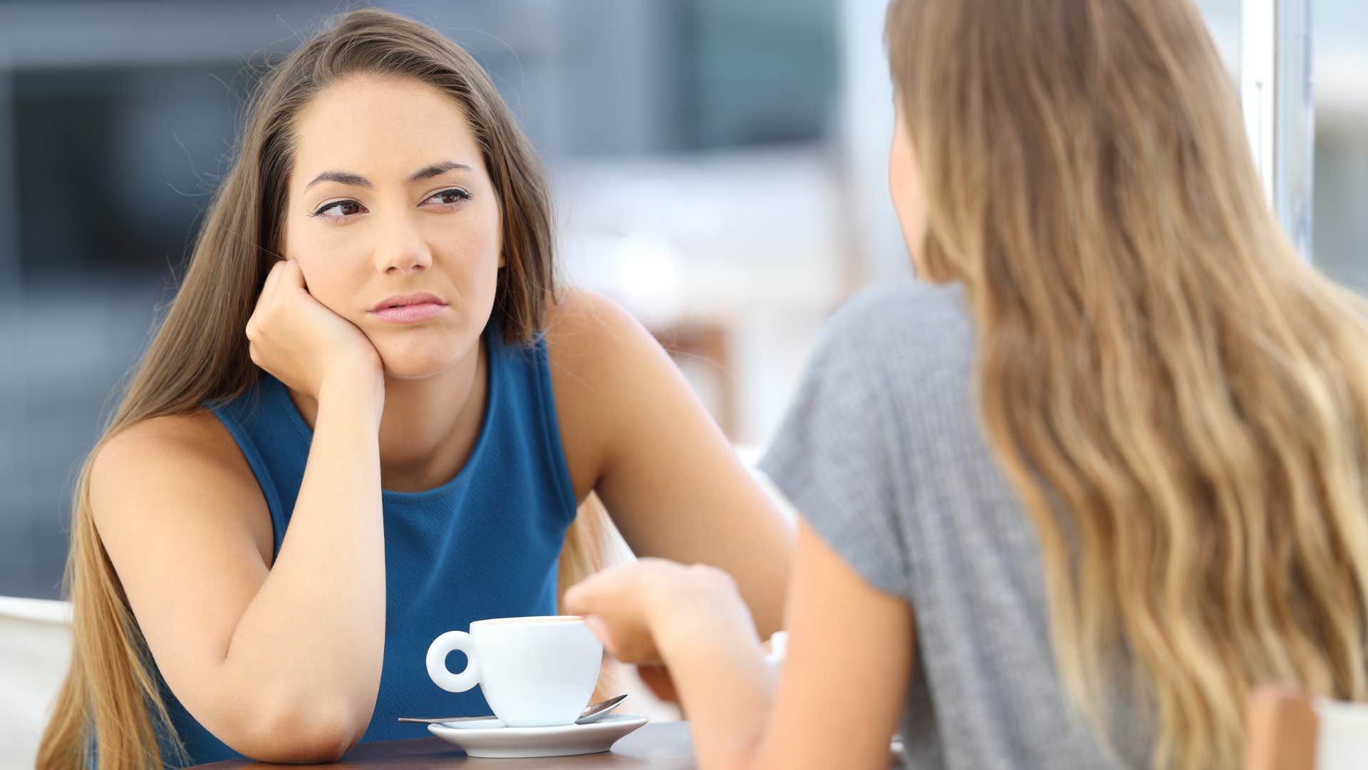 Woman looking annoyed while talking to a friend.