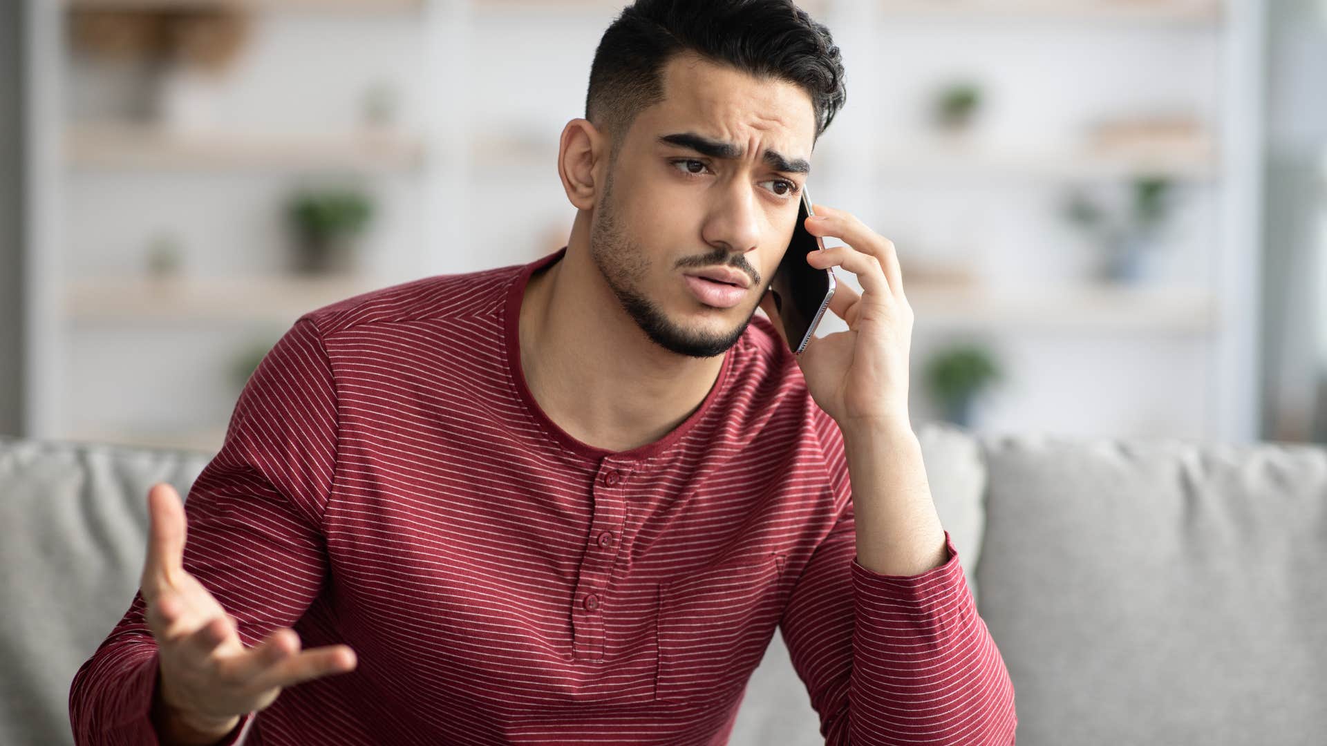 Man looking upset while talking on the phone.