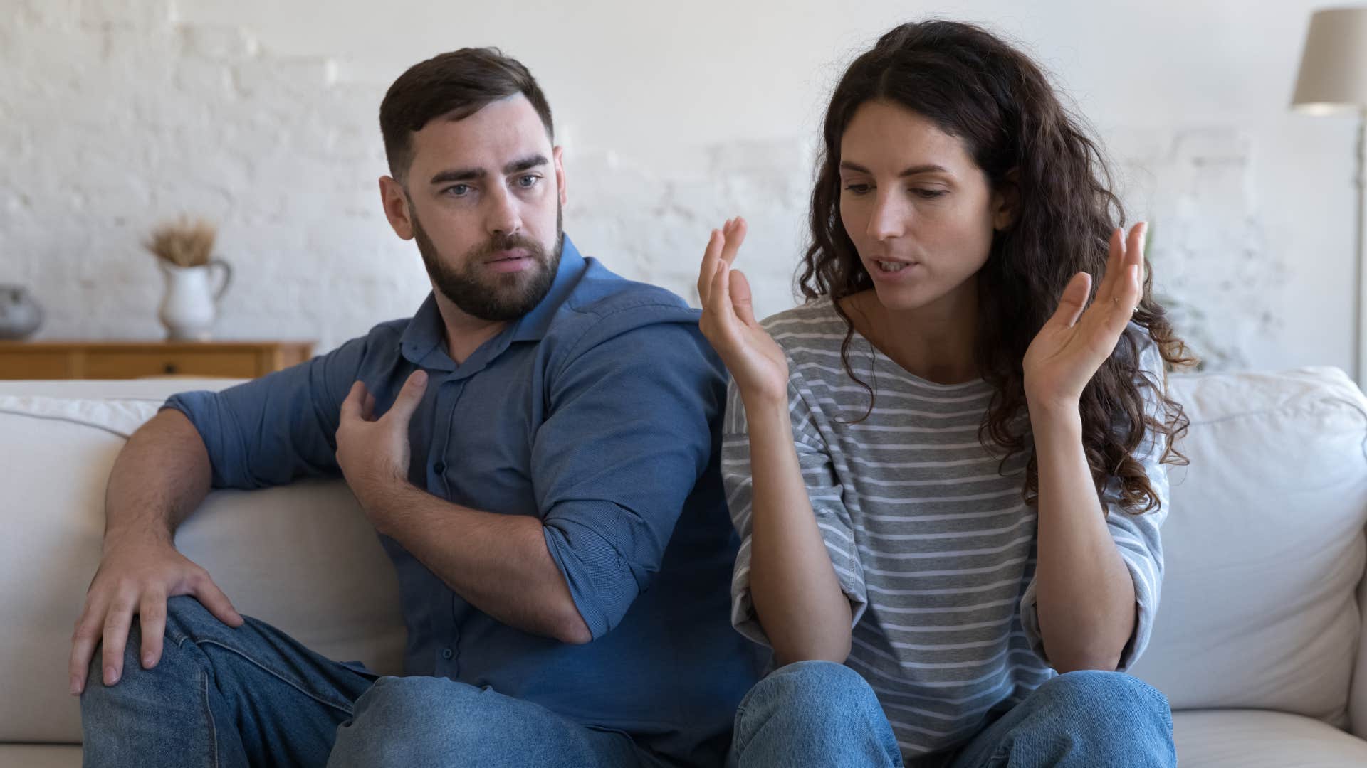 Woman looking annoyed while her husband sits beside her