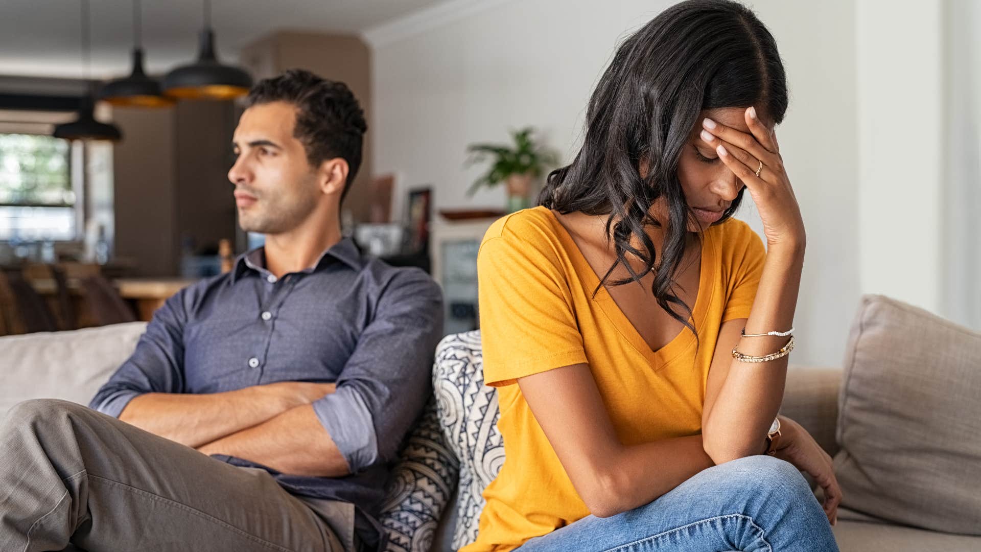 Woman upset next to her husband on the couch