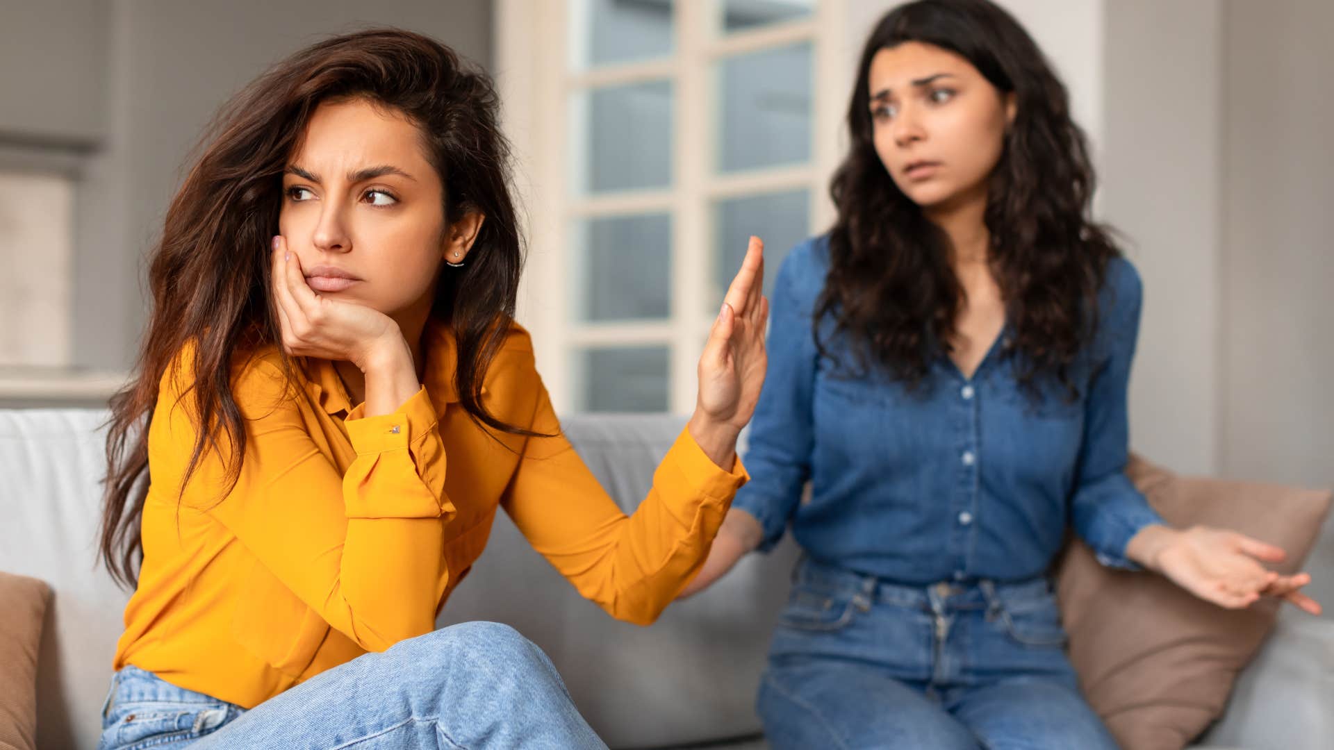 Woman holding her hand up in another woman's face