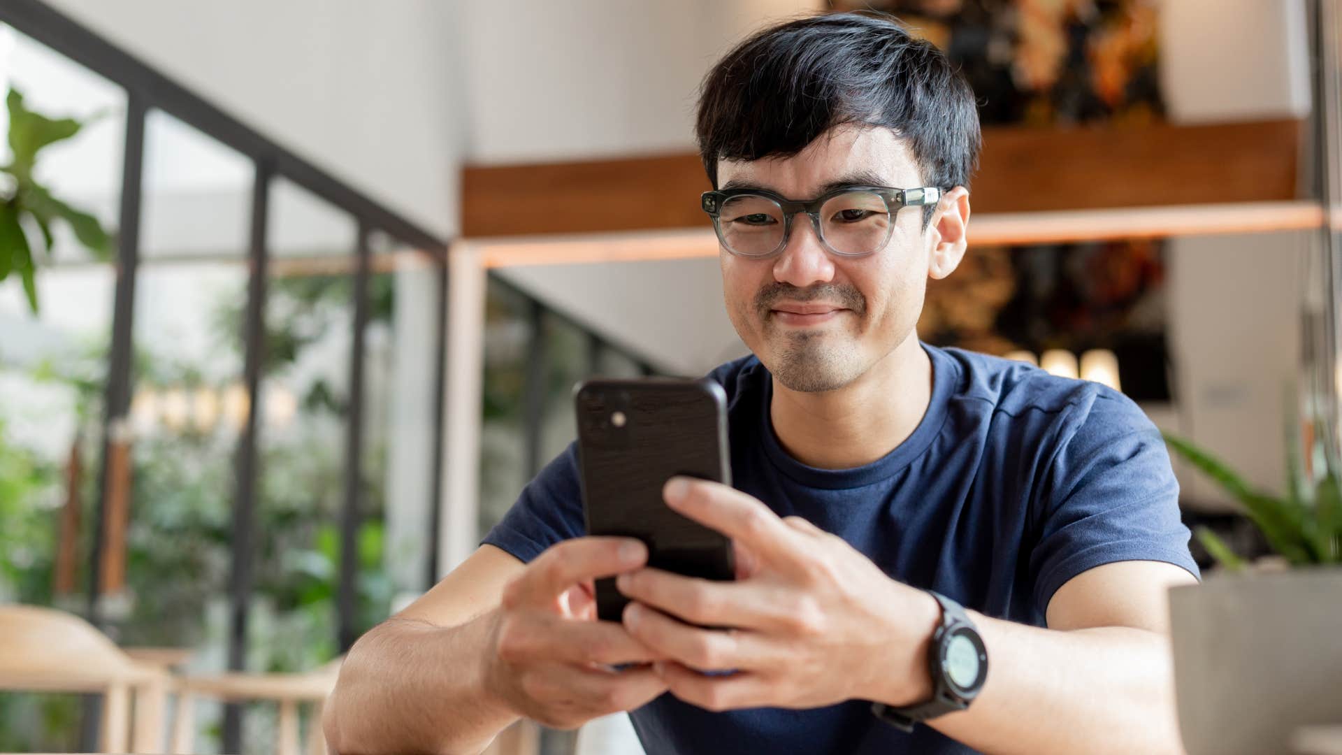 Man looking smug texting on his cell phone.