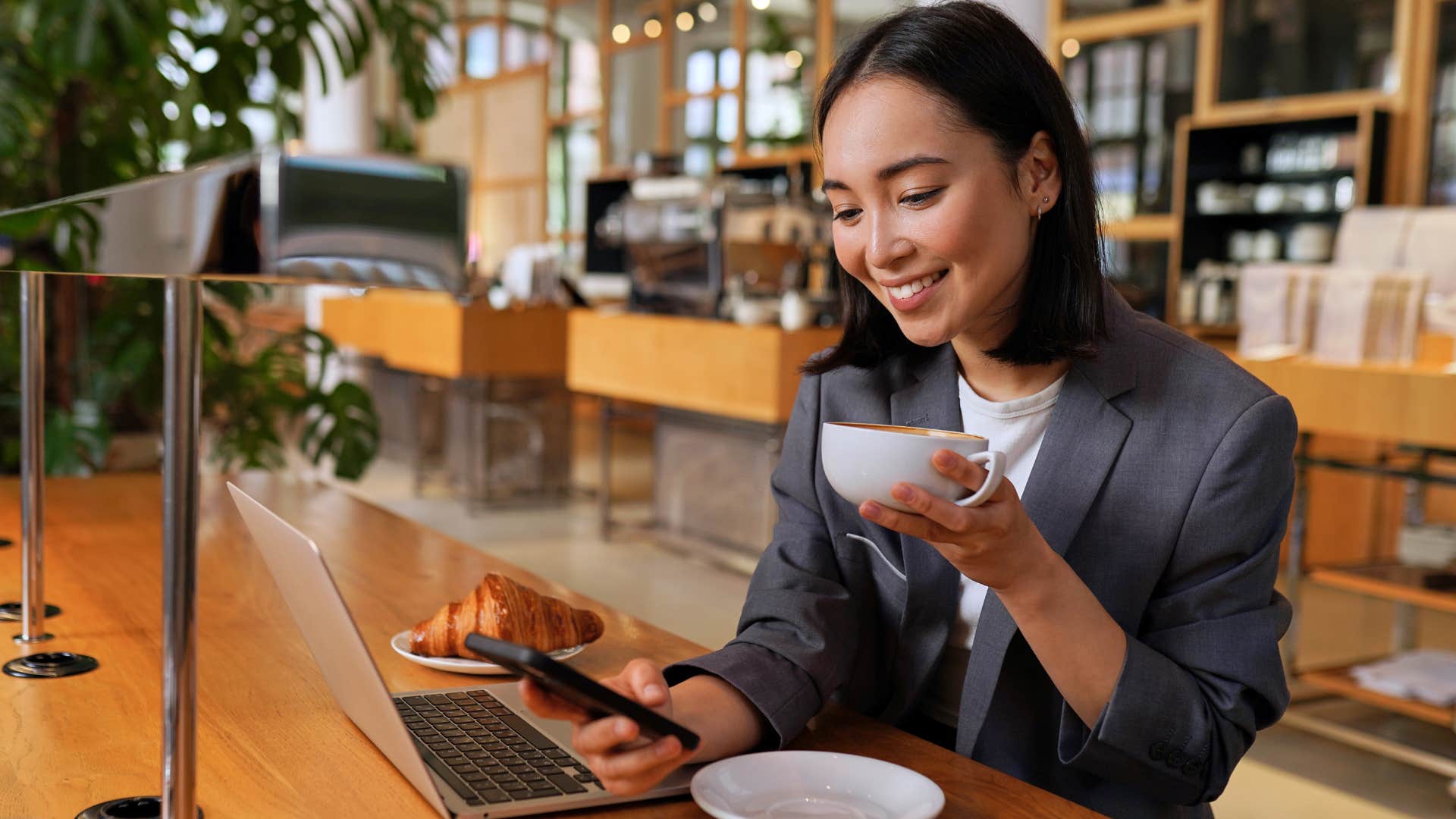 Professional young woman smiling and looking at her phone.