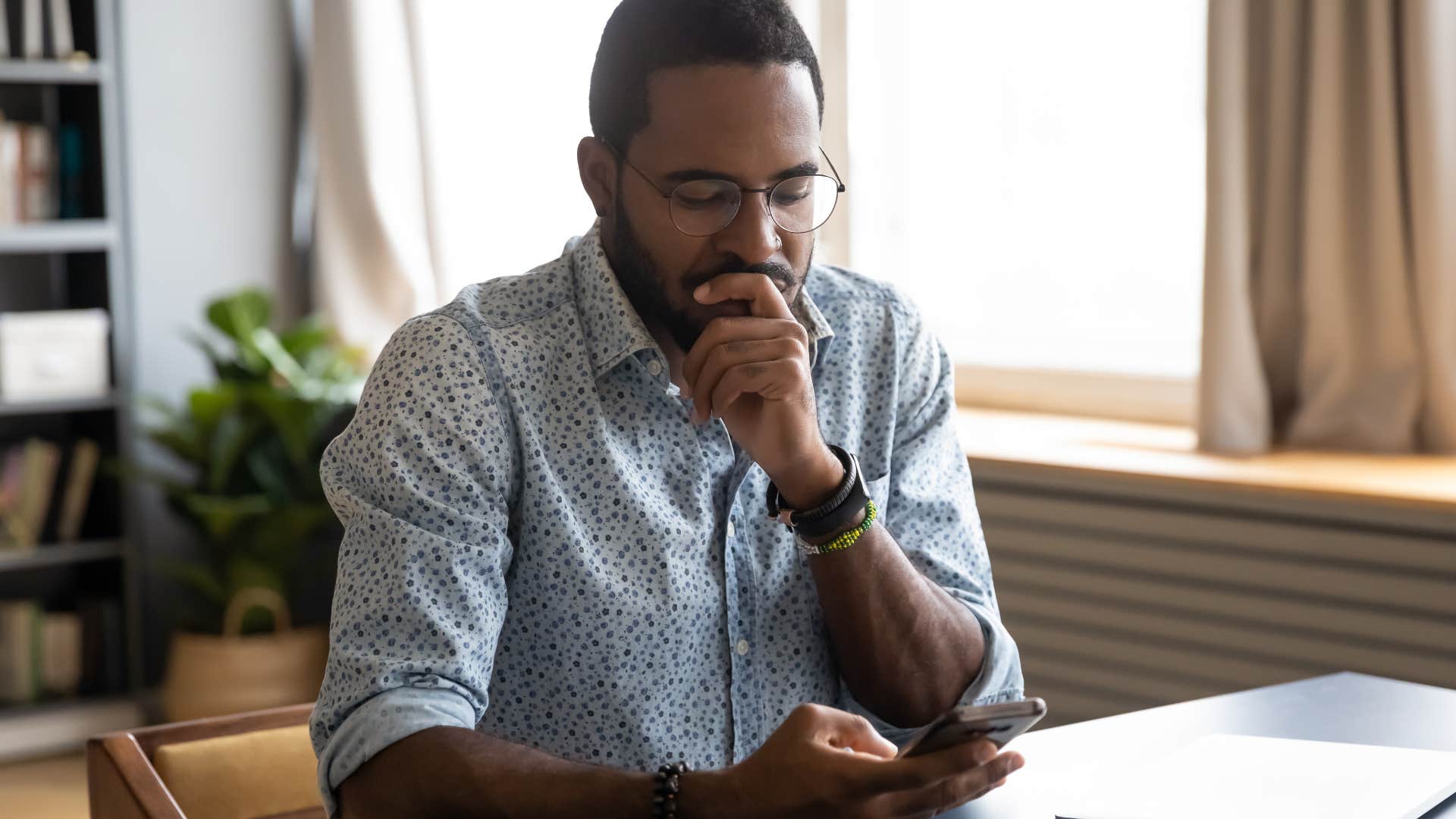 Man looking upset while texting on his phone.